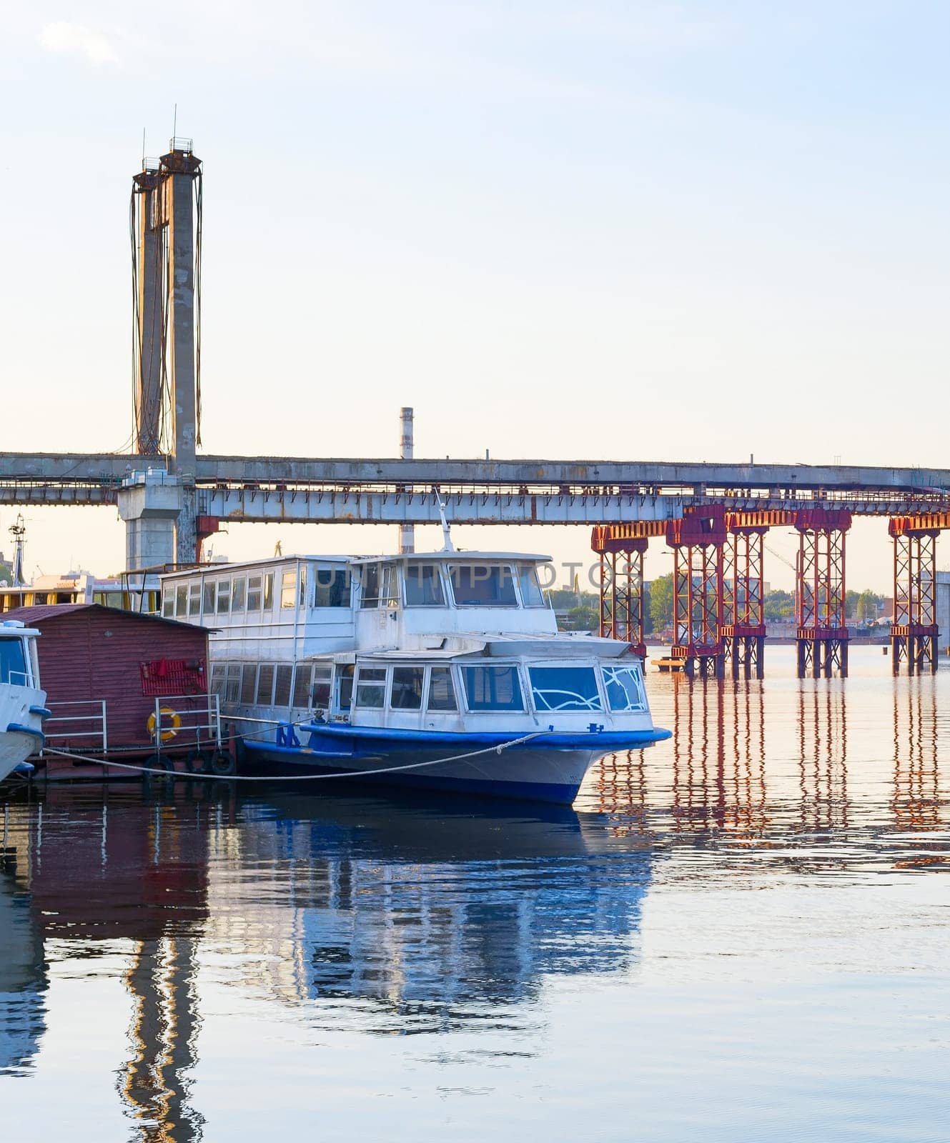 Abandoned old bridge over the Dnipro river. Old soviet passenger boat. Kyiv, Ukraine