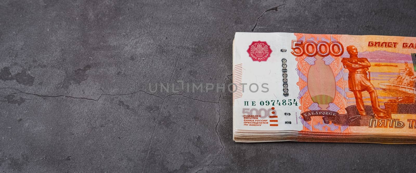 Russian rubles a large bundle on a gray background. A bundle of five-thousand-ruble notes. Place for logo, text, layout, mockup.