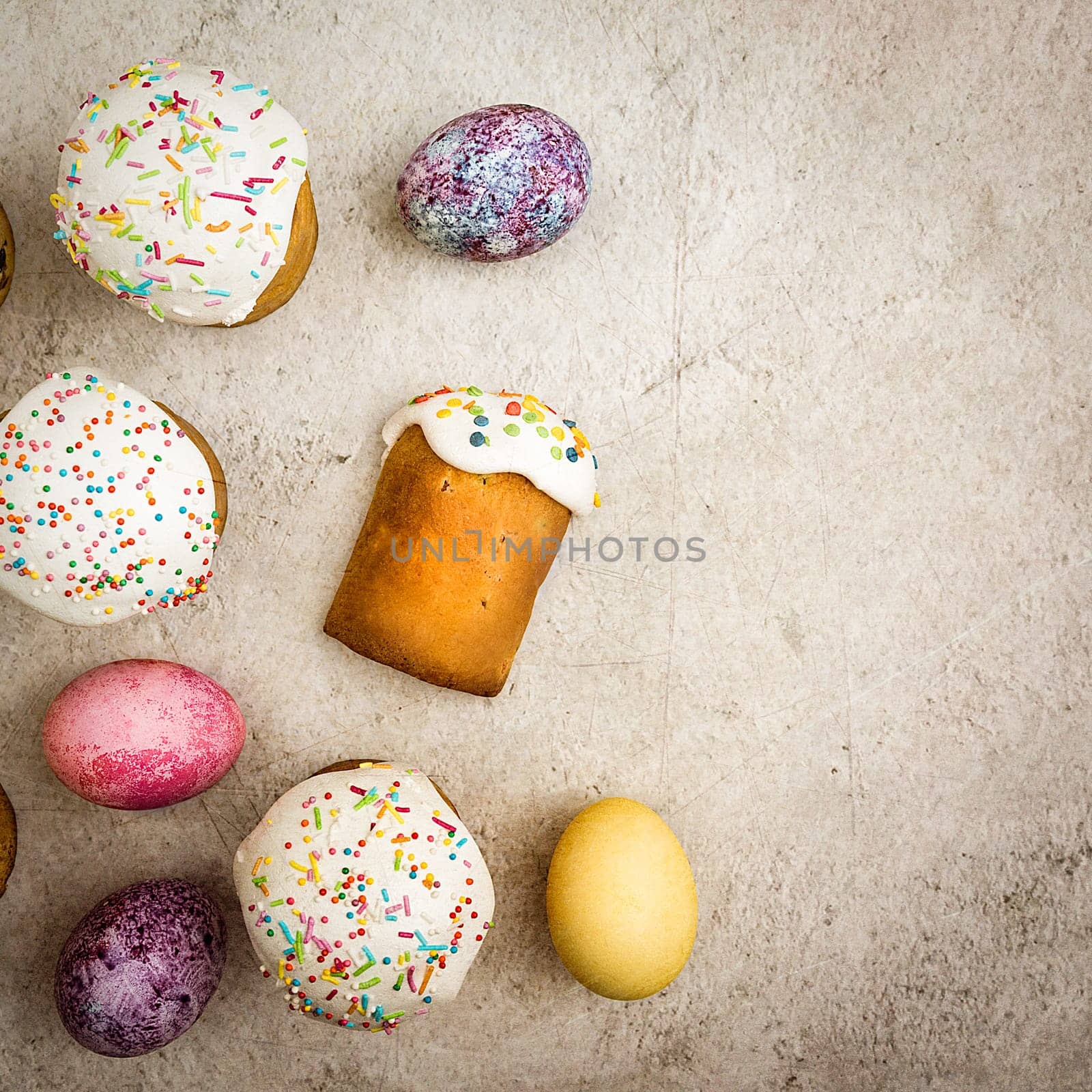 Easter cakes and Easter colored eggs on a beautiful textured background. Religious holiday of bright Easter.