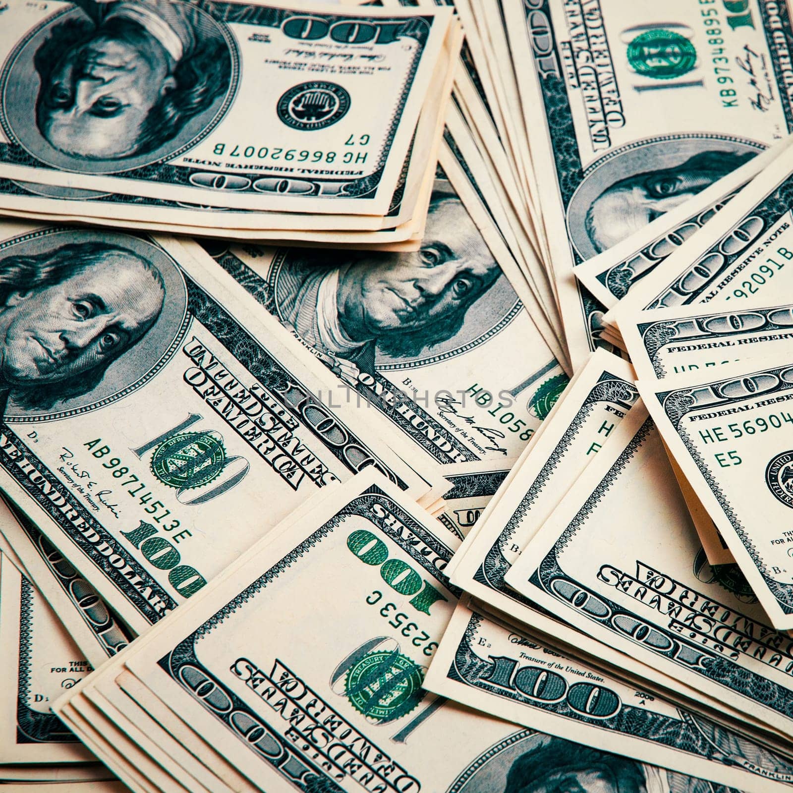 Cash of hundred dollar bills, dollar background image. One hundred US banknotes are scattered over the background.