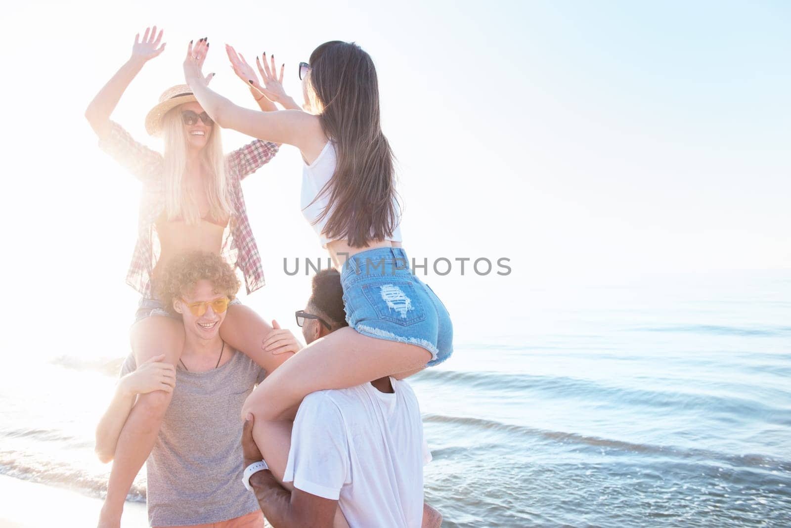 Happy smiling couples playing at the sunny beach