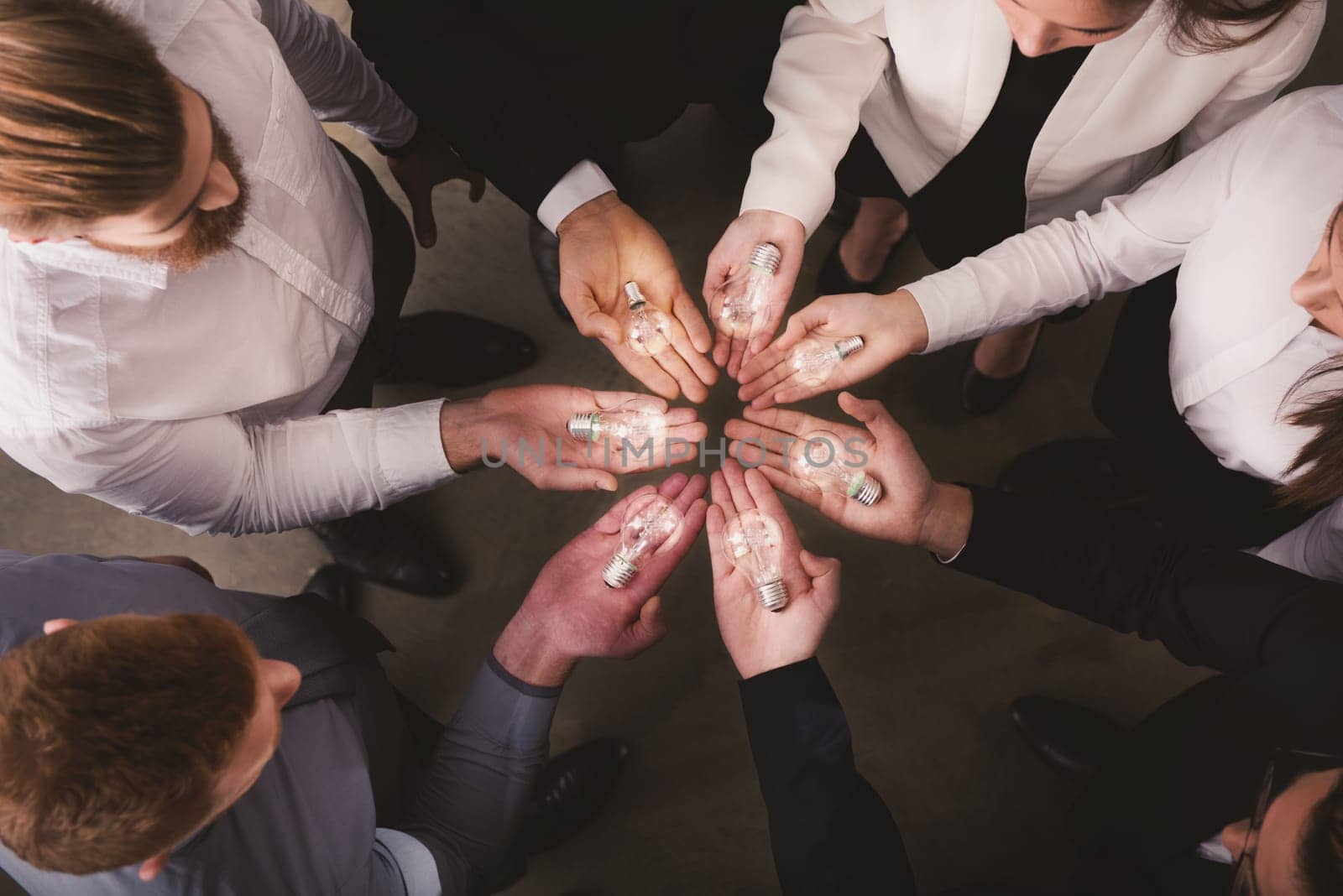Teamwork and brainstorming concept with businessmen that share an idea with a lamp. Concept company startup