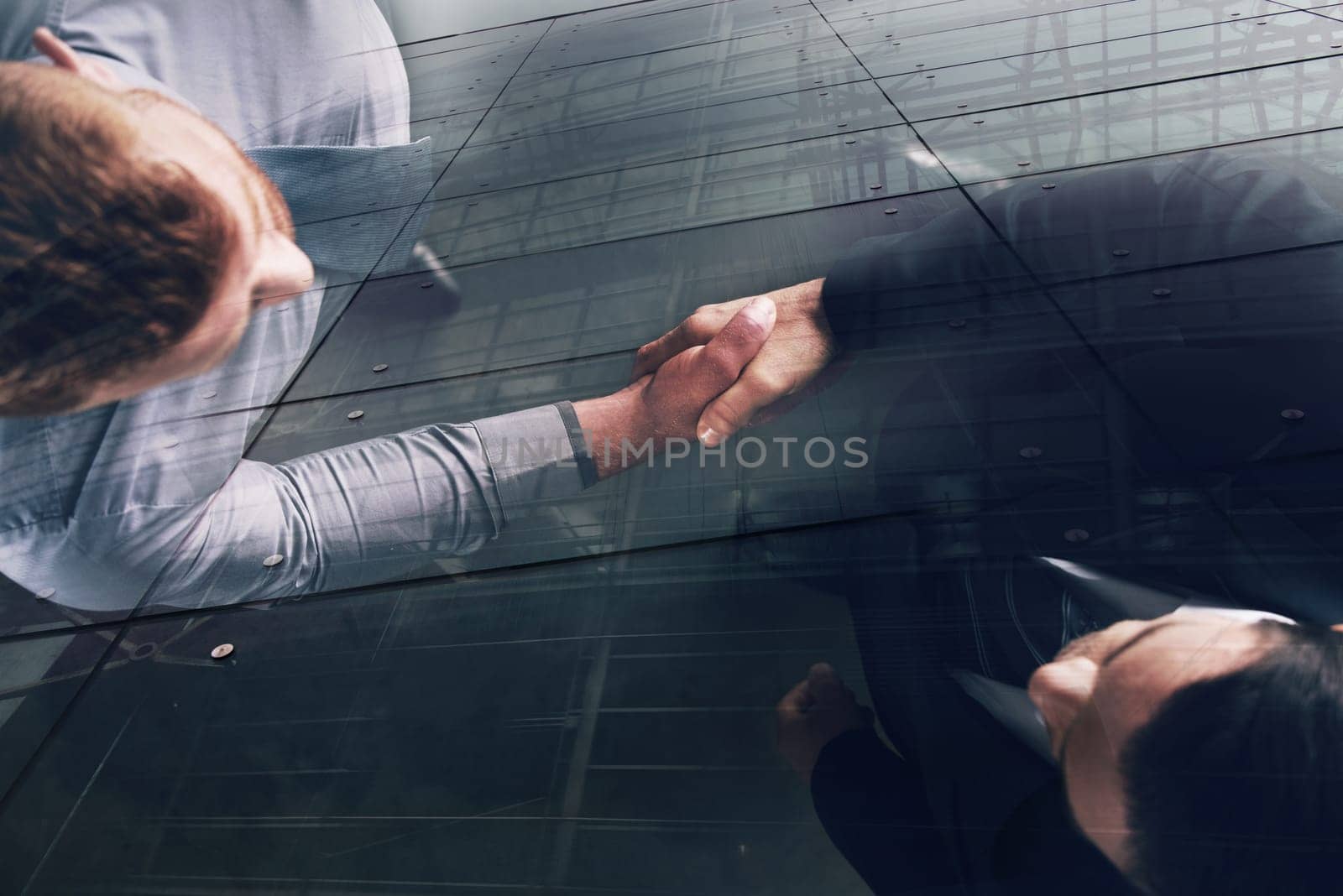 Handshaking business person in the office. concept of teamwork and business partnership. double exposure