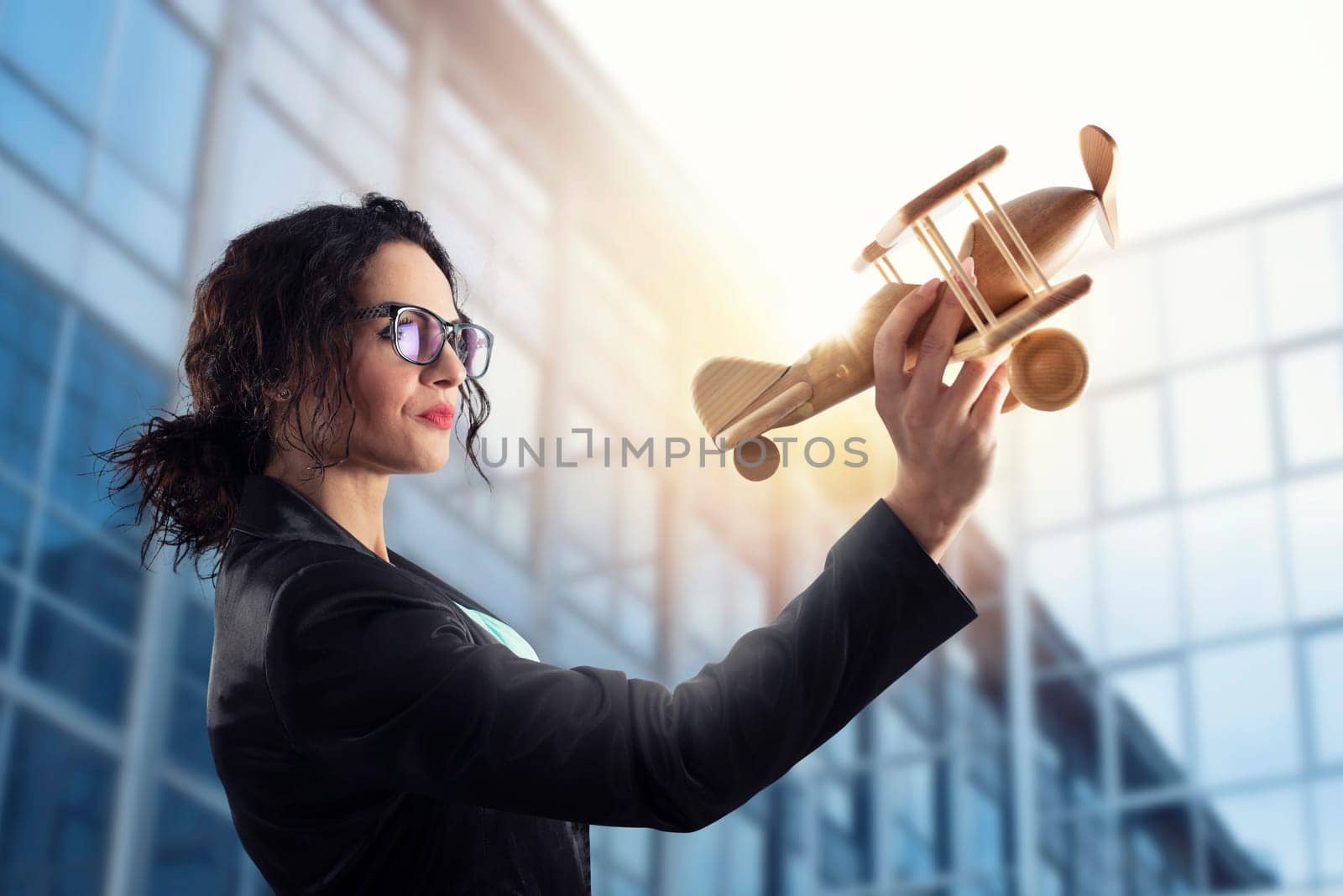 Businesswoman play with a wooden toy aircraft. Concept of company startup and business success