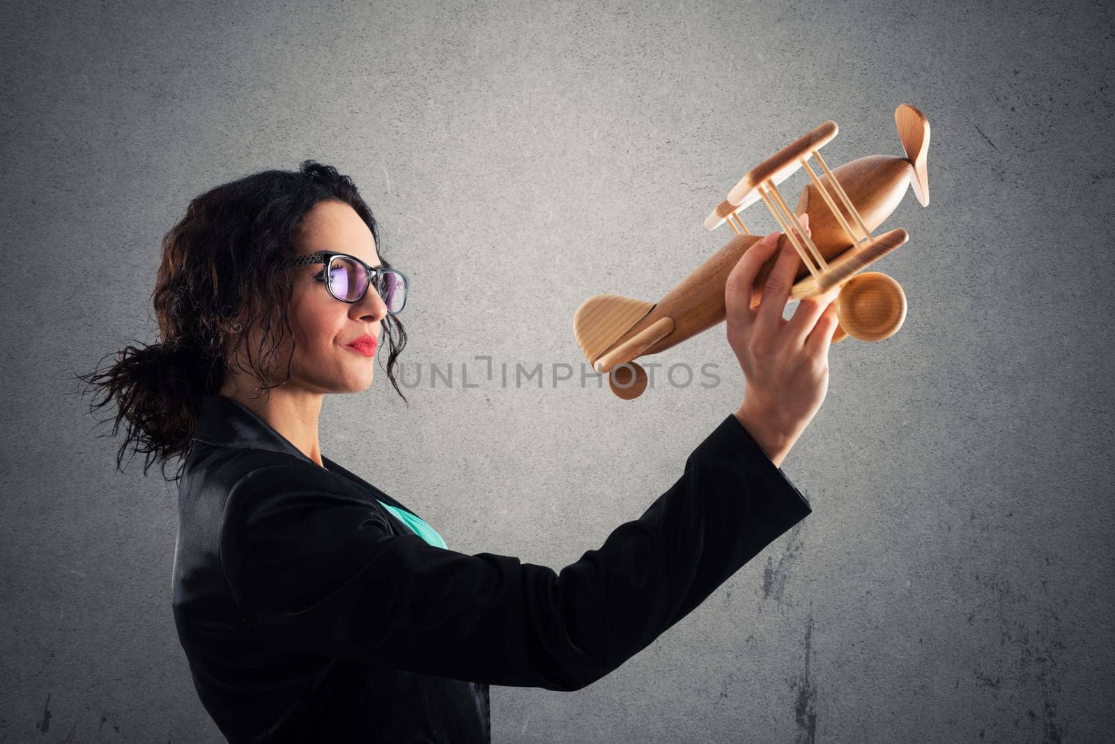 Businesswoman play with a wooden toy aircraft. Concept of company startup and business success