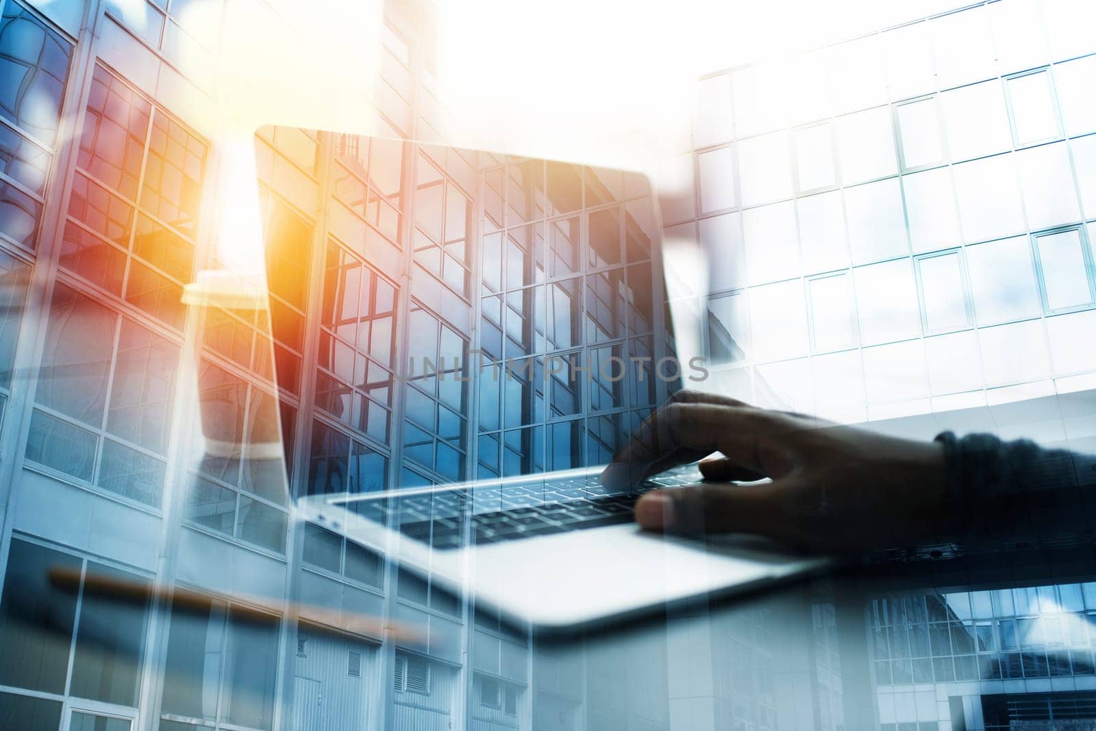 Businessman works in office with a laptop. Concept of internet sharing and company startup. double exposure