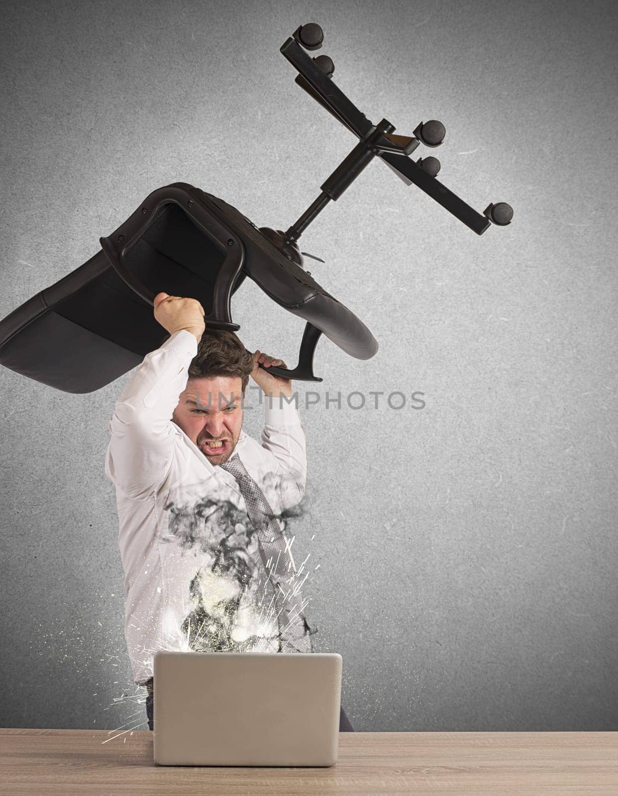Stressed businessman breaks the computer with chair