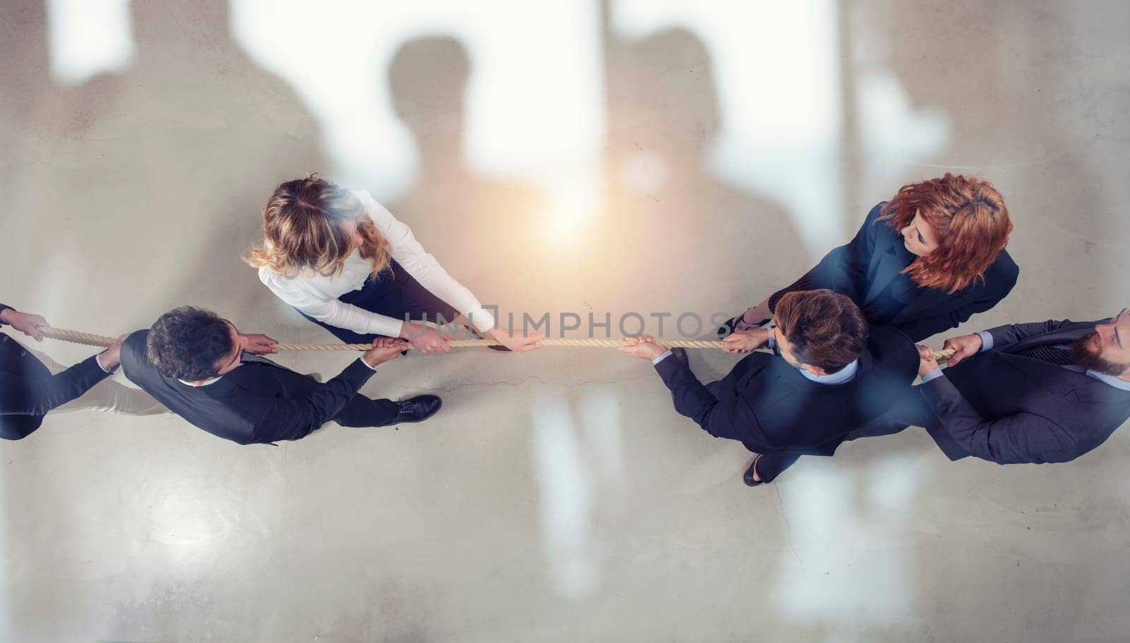 Rival business man and woman compete in office for the command by pulling the rope. double exposure