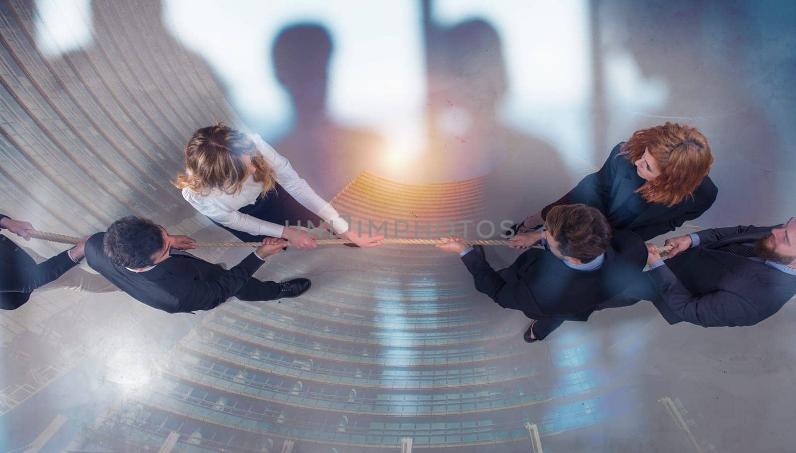 Rival business man and woman compete in office for the command by pulling the rope. double exposure