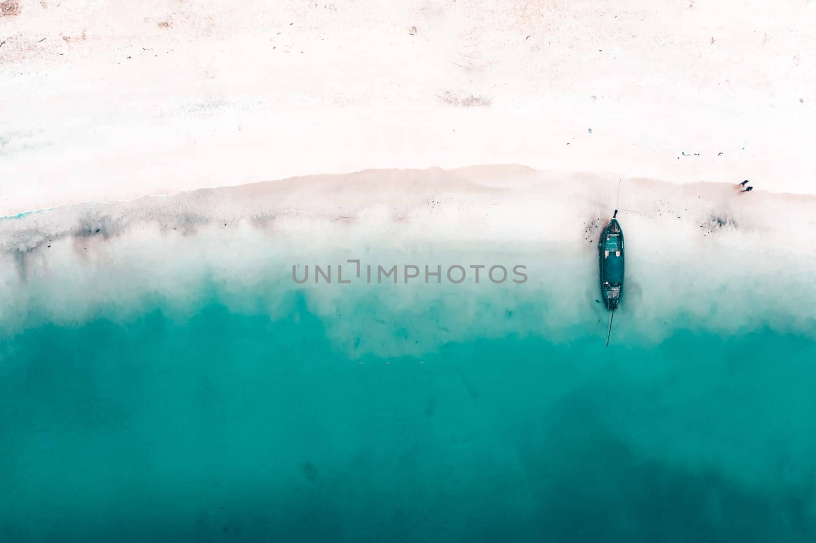 Aerial, drone view of a beautiful tropical beach with white sand, turquoise clear water and longtail boat near Krabi, Thailand.