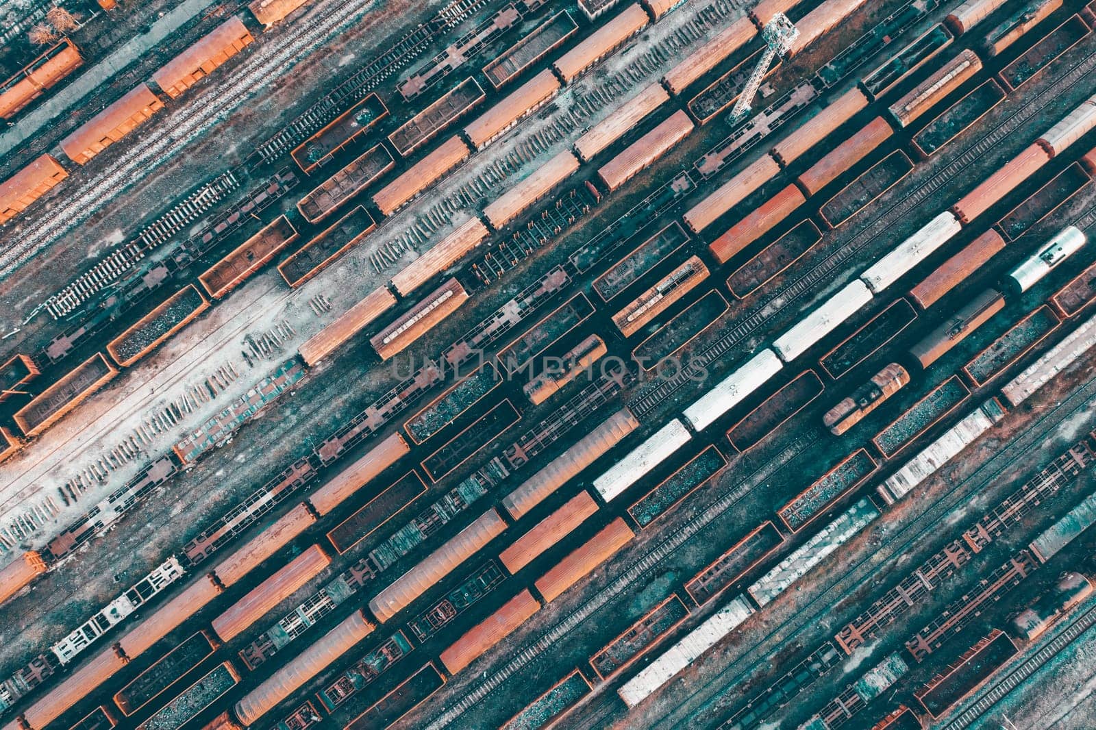 Aerial view of various railway carriage trains with goods on the railway station, top view.