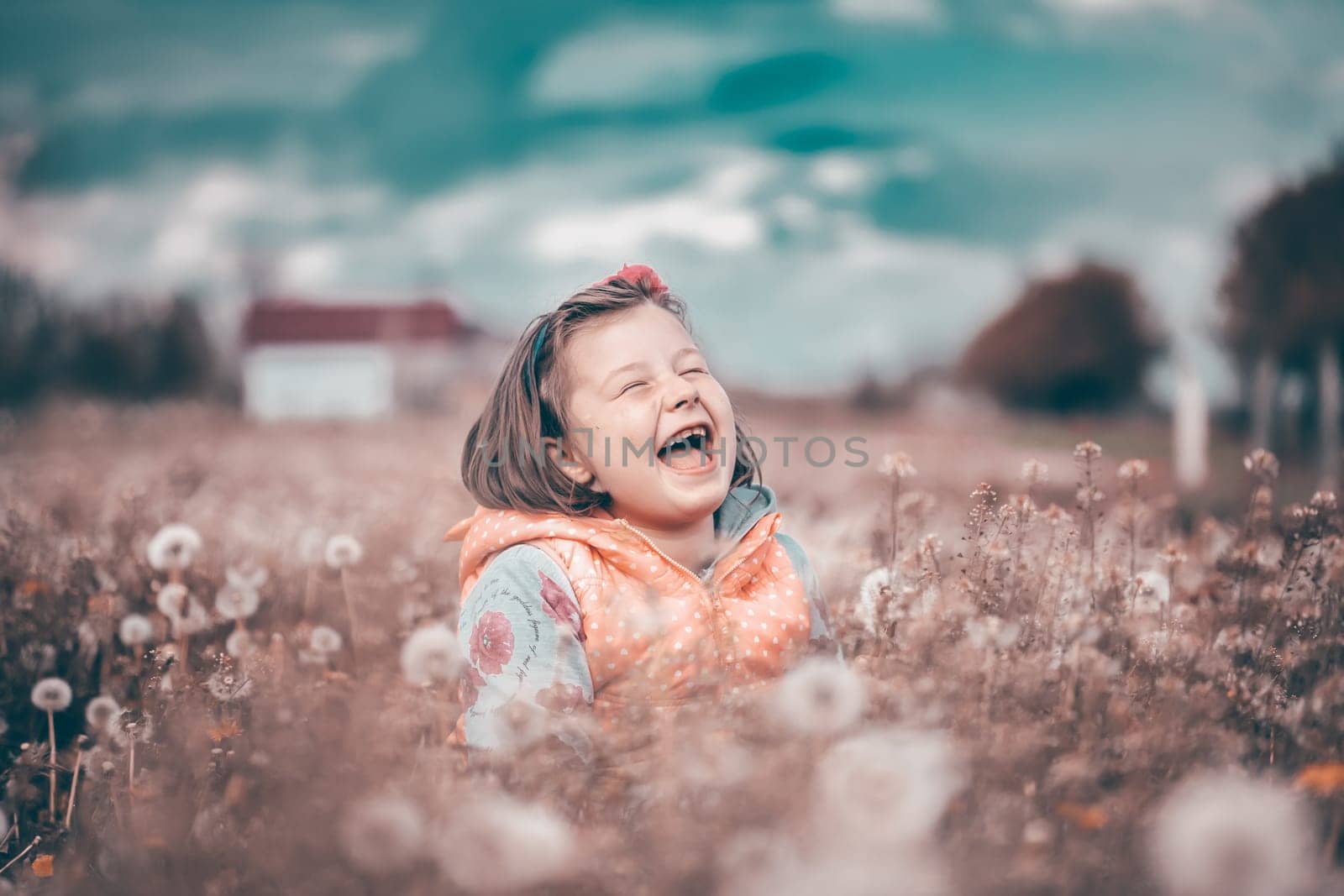 Sweet little girl having fun in spring dandelion field.