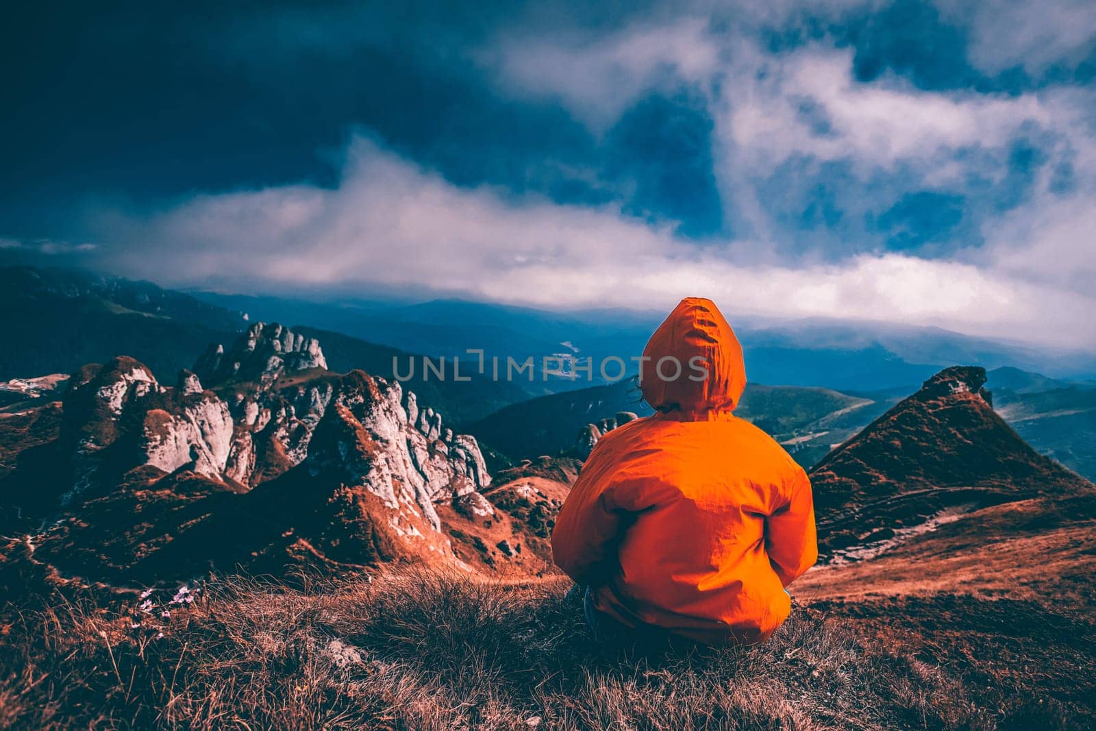 Woman sitting on cliff enjoying mountains landscape. Lifestyle concept. Traveling active adventure vacations.