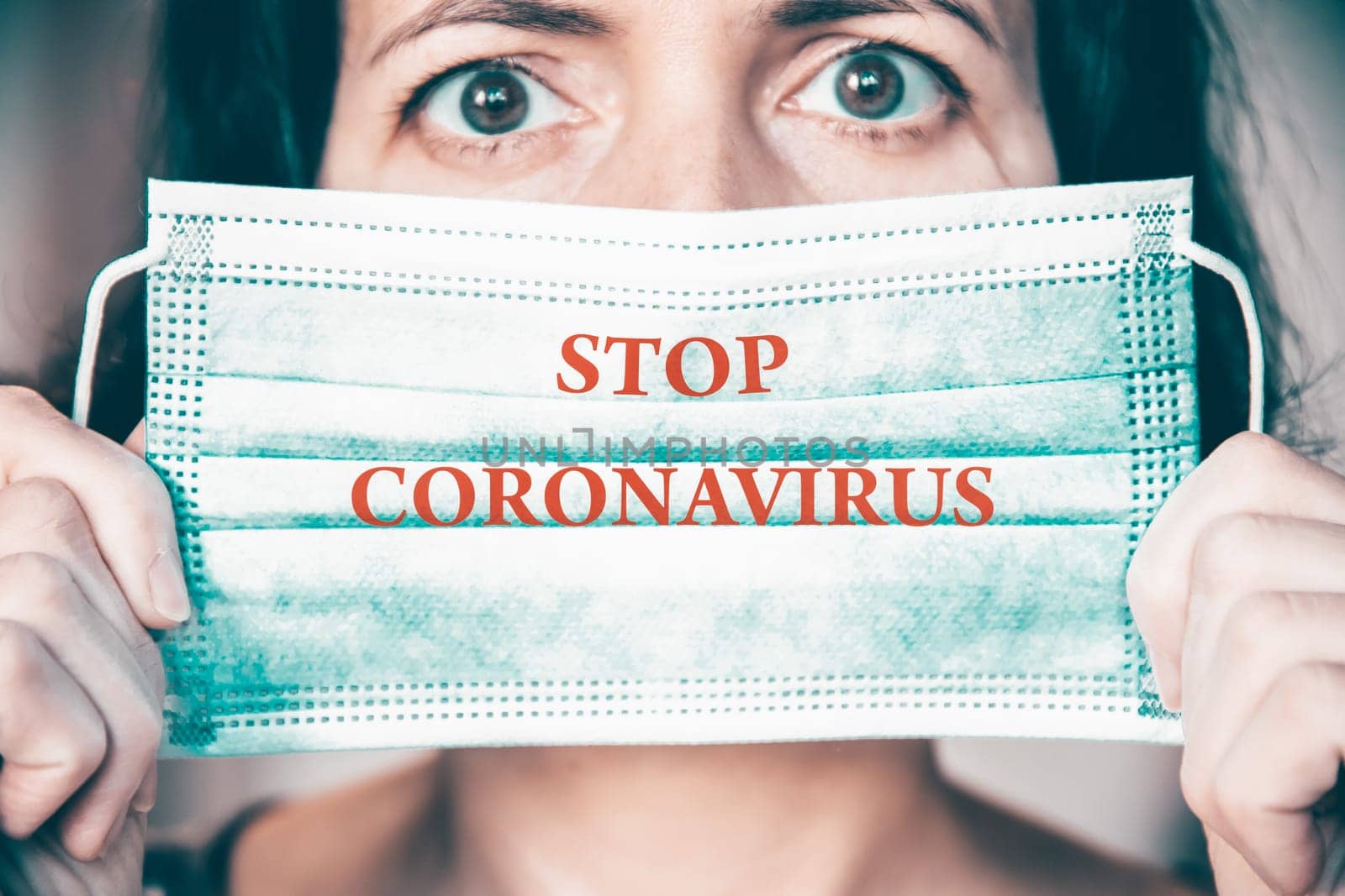 Woman wearing medical protective surgical face mask with text Stop coronavirus. Concept of protection against Covid-19, coronavirus outbreak campaign.