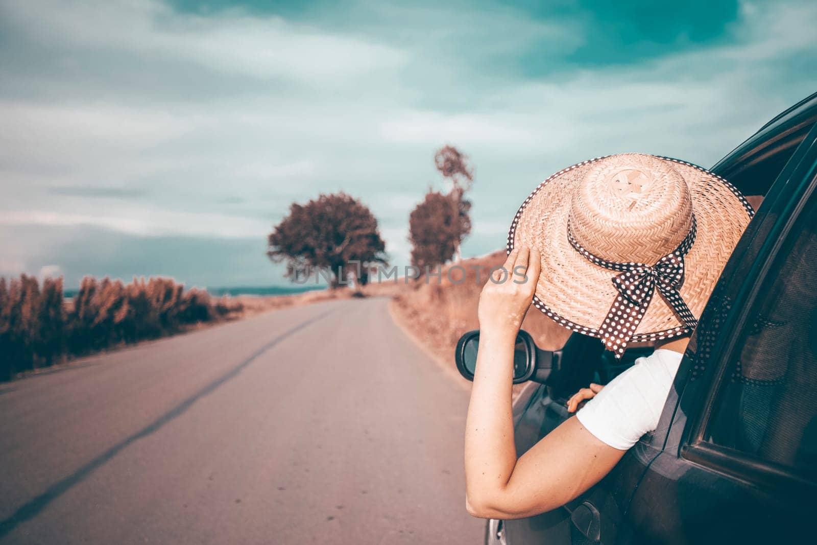 Young woman traveling in a car across Europe. Freedom, travel and vacation road trip concept lifestyle image.