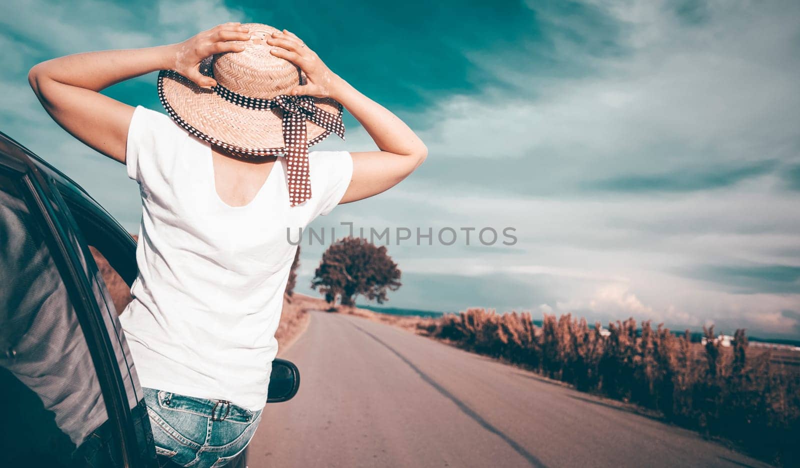 Young woman traveling in a car across Europe. Freedom, travel and vacation road trip concept lifestyle image.