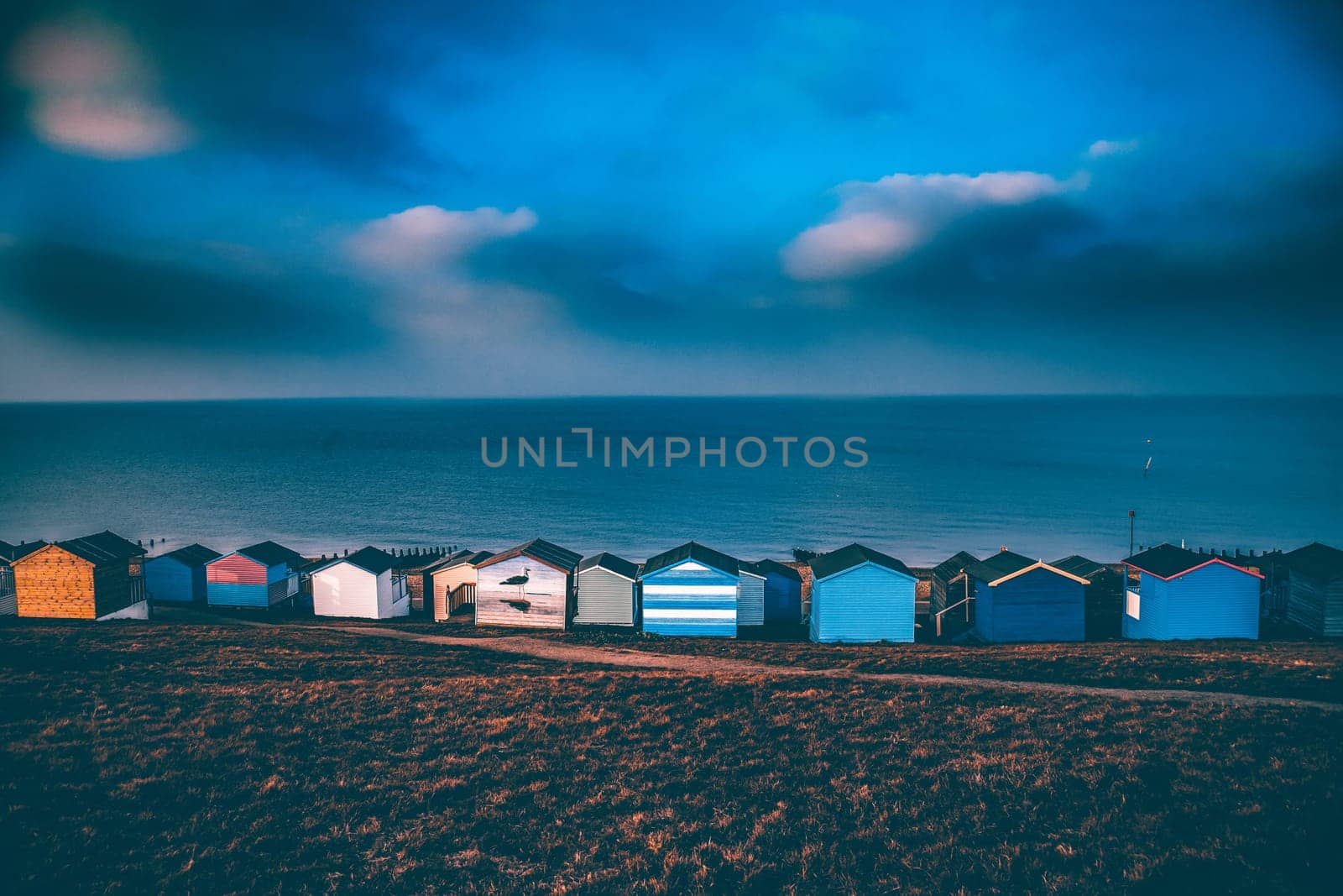 Colorful beach huts with stormy blue sky, beach of Tankerton near Whitstable in Kent, UK