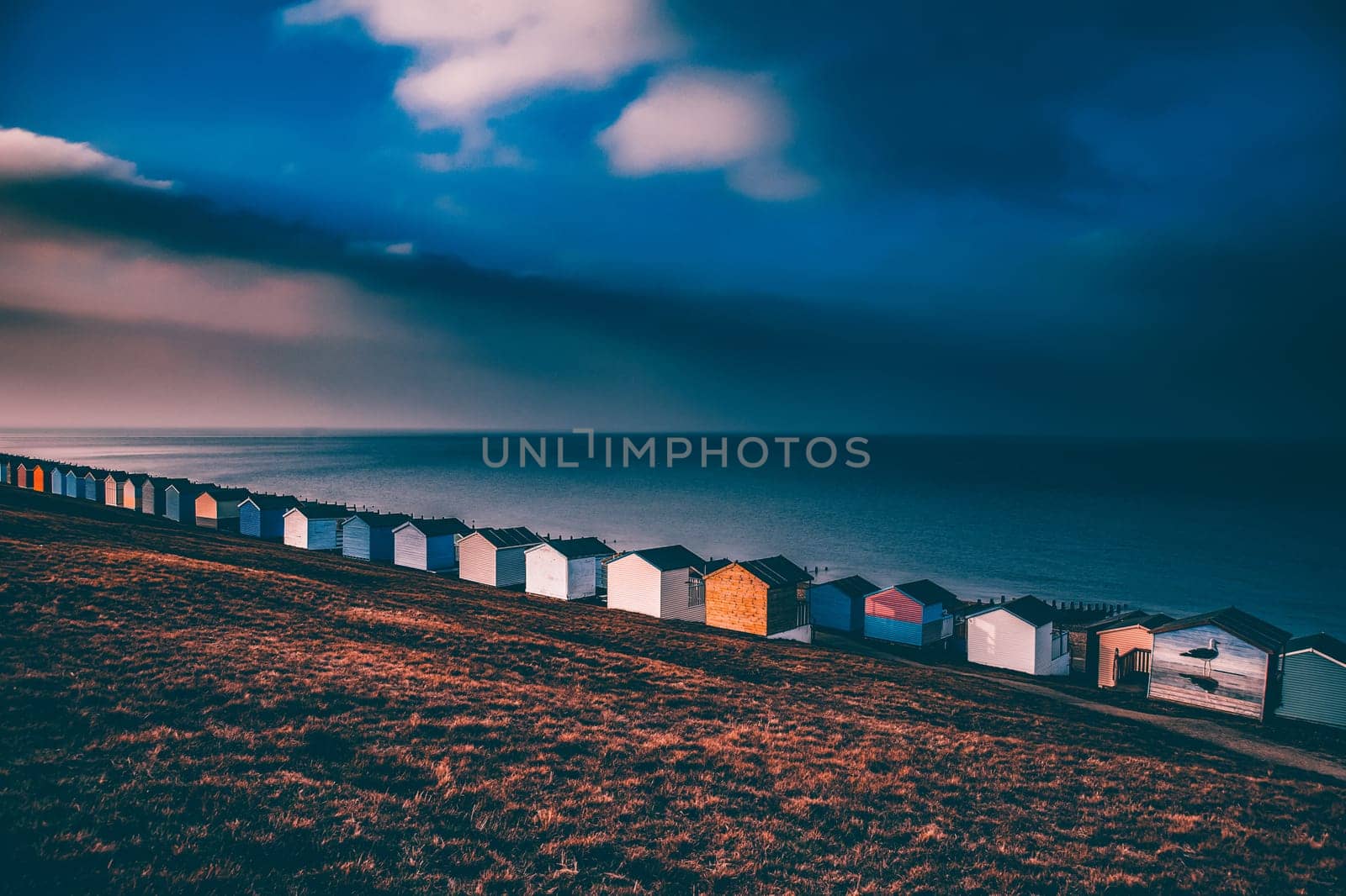 Colorful beach huts with stormy blue sky, beach of Tankerton near Whitstable in Kent, UK