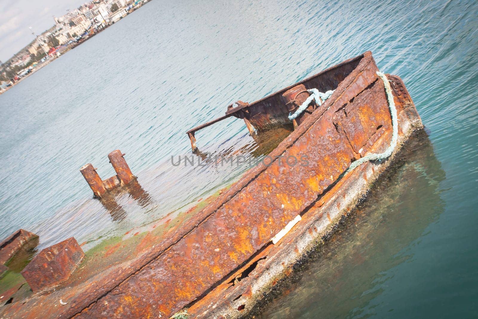 Rusty wreck moored, abandoned in the pier in the harbor of Cagliari Sardinia.