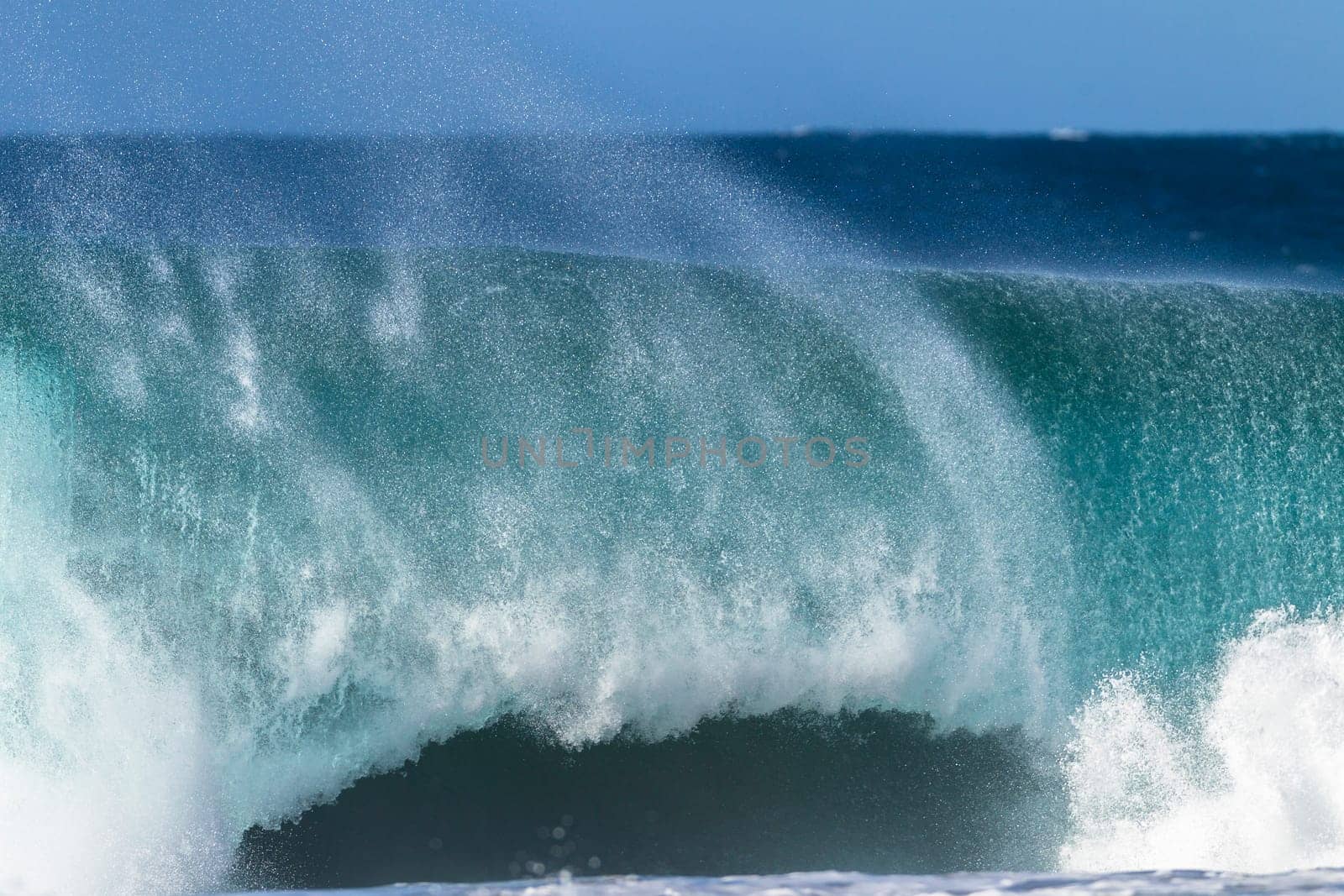 Ocean large wave swell crashing hollow water energy power of nature on coastline beach.