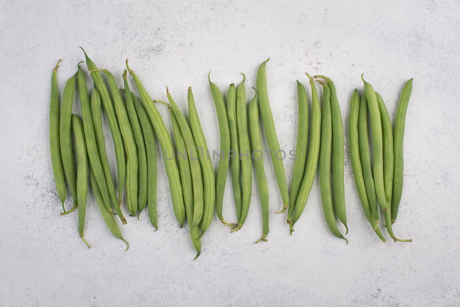 Green string beans on a textured background, empty space for text, fresh vegetables