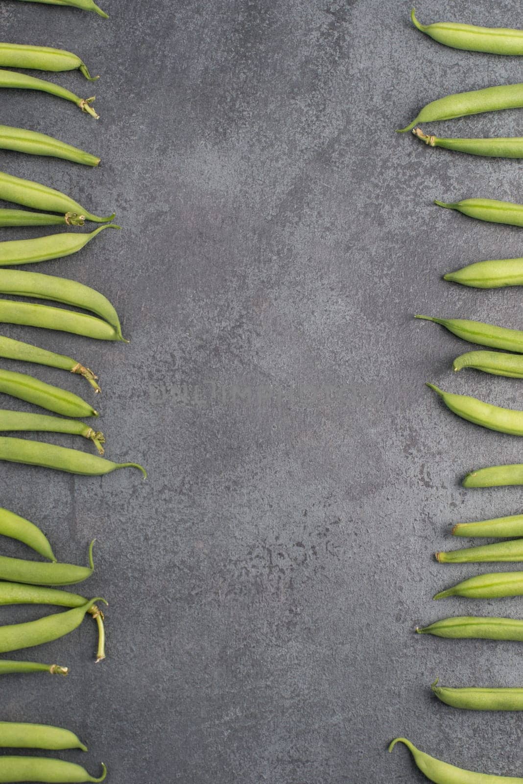 Green string beans on a textured background, empty space for text, fresh vegetables