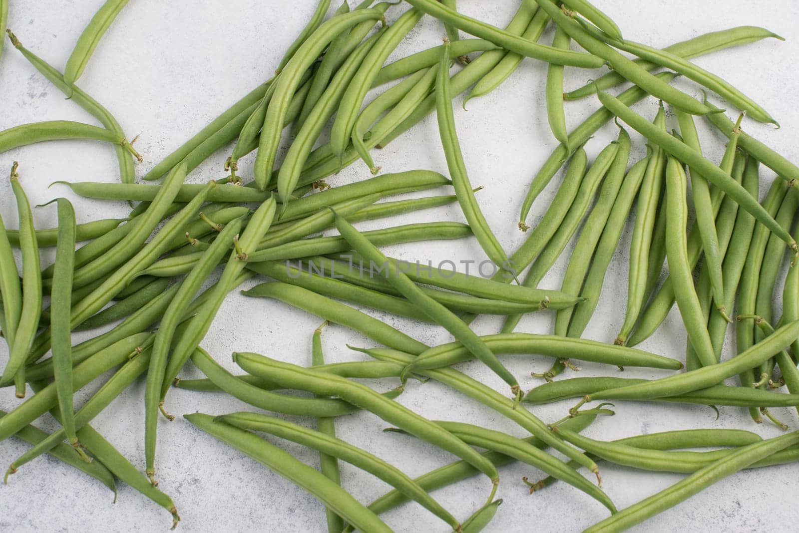 Green string beans on a textured background, empty space for text, fresh vegetables