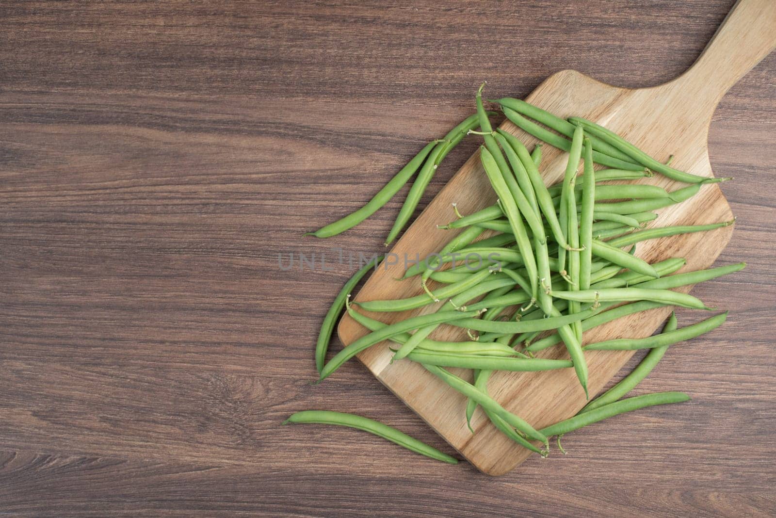 Green string beans on a textured background, empty space for text, fresh vegetables