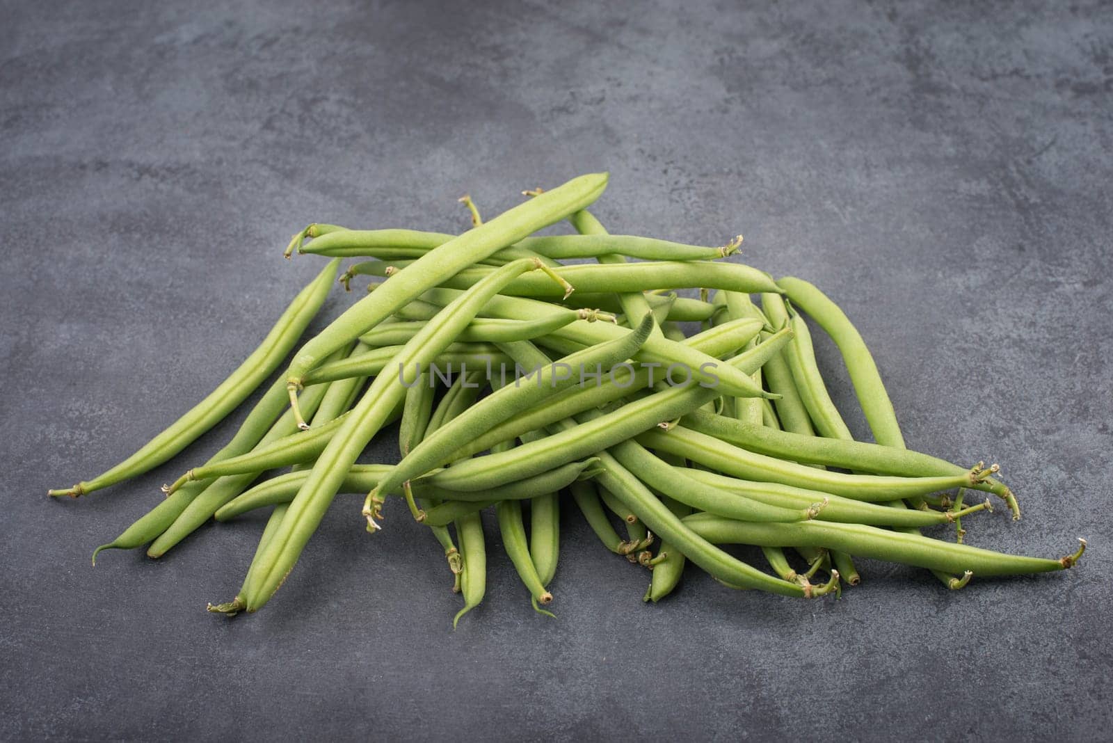 Green string beans on a textured background, empty space for text, fresh vegetables
