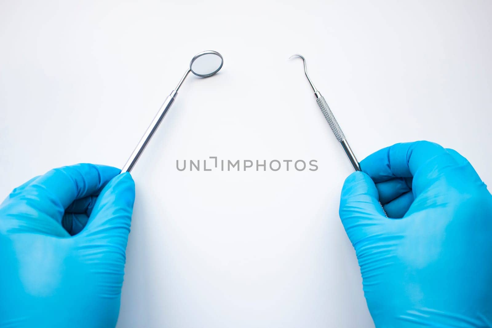 Dentist mirror and probe in hands isolated on white. Professional Dental Hygiene cleaning tools. Calculus and Plaque Remover Set, Dental Scaler And Mouth Mirror Instruments Hygienist tools.