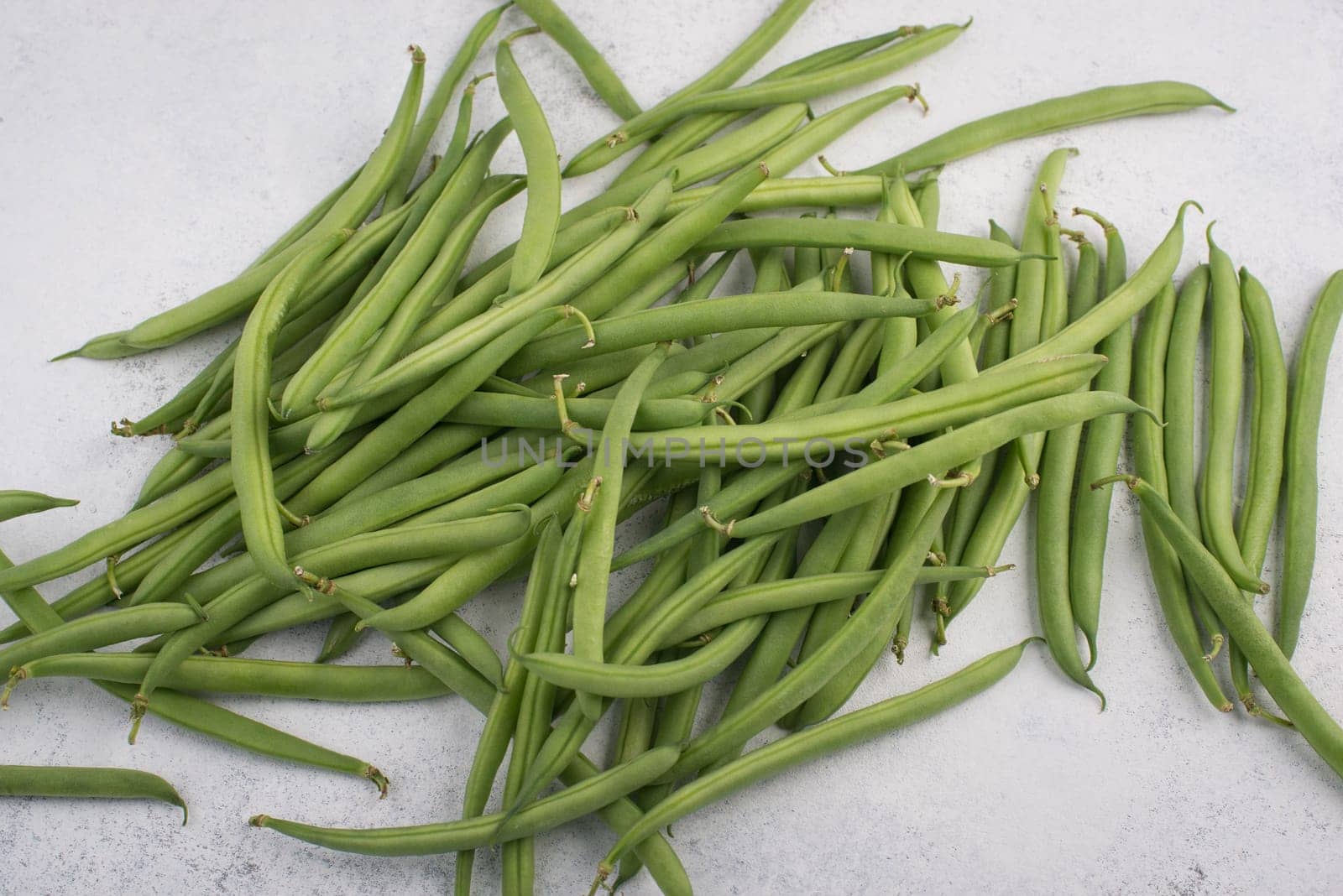 Green string beans on a textured background, empty space for text, fresh vegetables