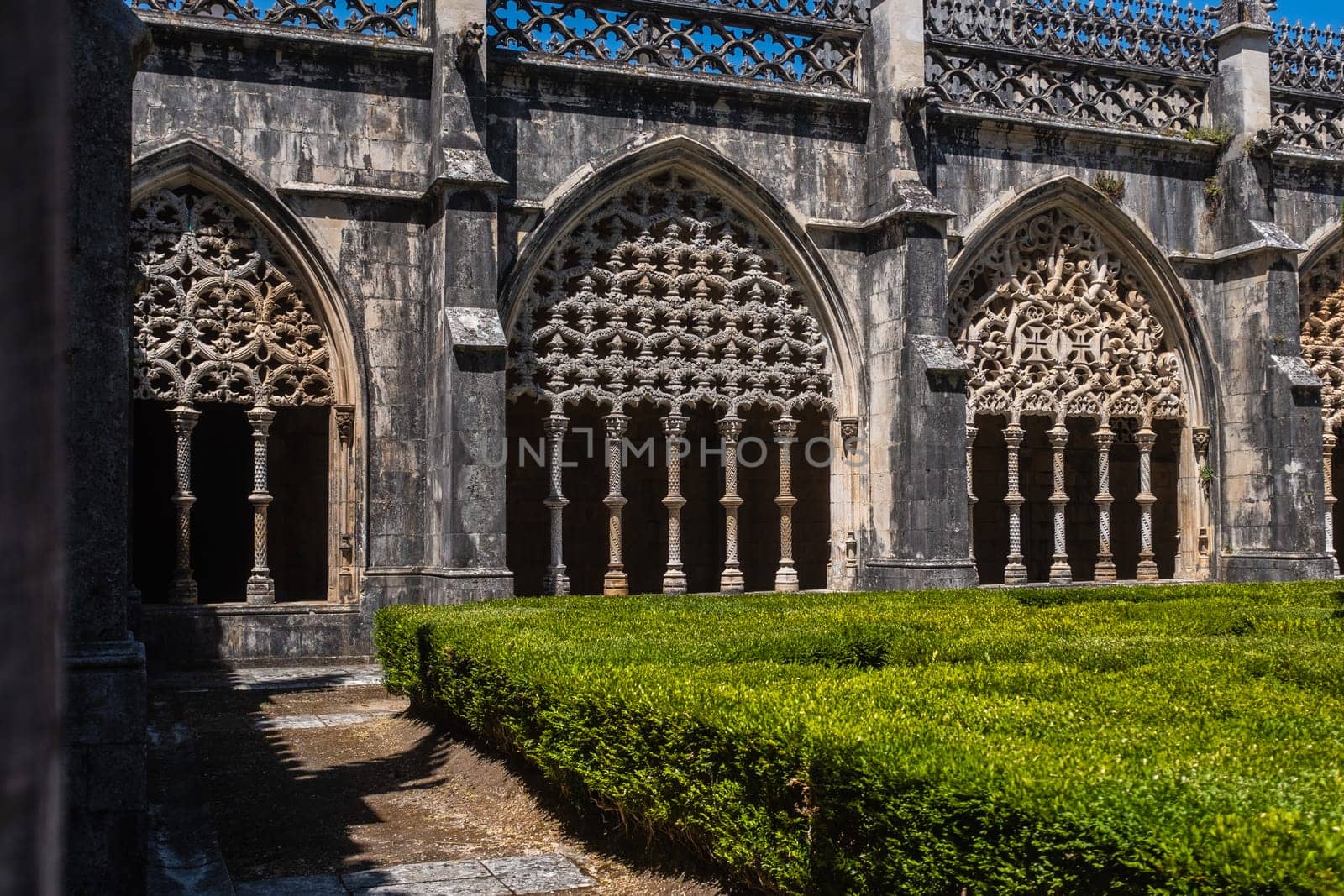 View of the richly decoration arches in the cloister hall of the Monastery of Batalha, a Dominican order convent located in the district of Leiria, in Portugal.