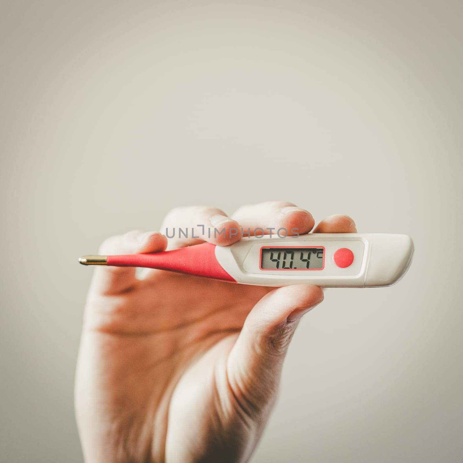 Man is holding a fever thermometer in his hand