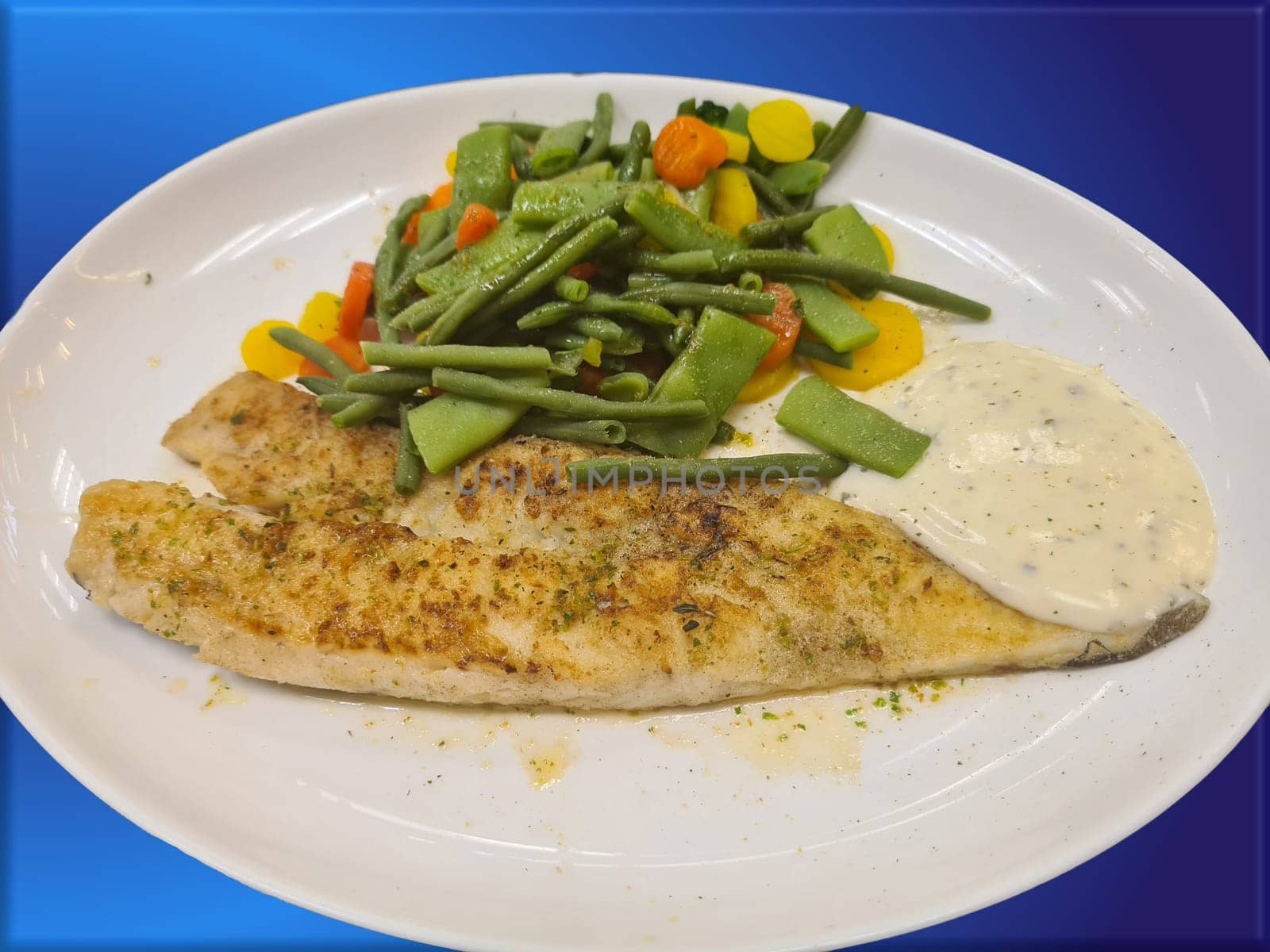 Fried fish on green asparagus with salad