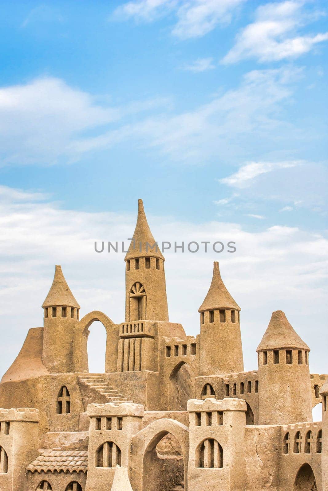 Sandcastle during a sunny day with blue sky background. Concept for summer, vacation, relax and fun.