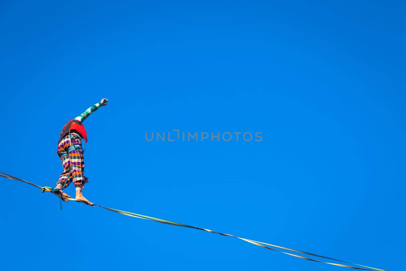 LANZO, ITALY - CIRCA OCTOBER 2020: Slackline athlete during his performance. Concentration, balance and adventure in this dynamic sport.
