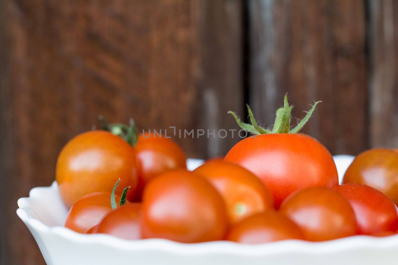 Delicious fresh and juicy vegetables from farming agriculture. Organic nature solanum tomato food on wooden background with copyspace.
