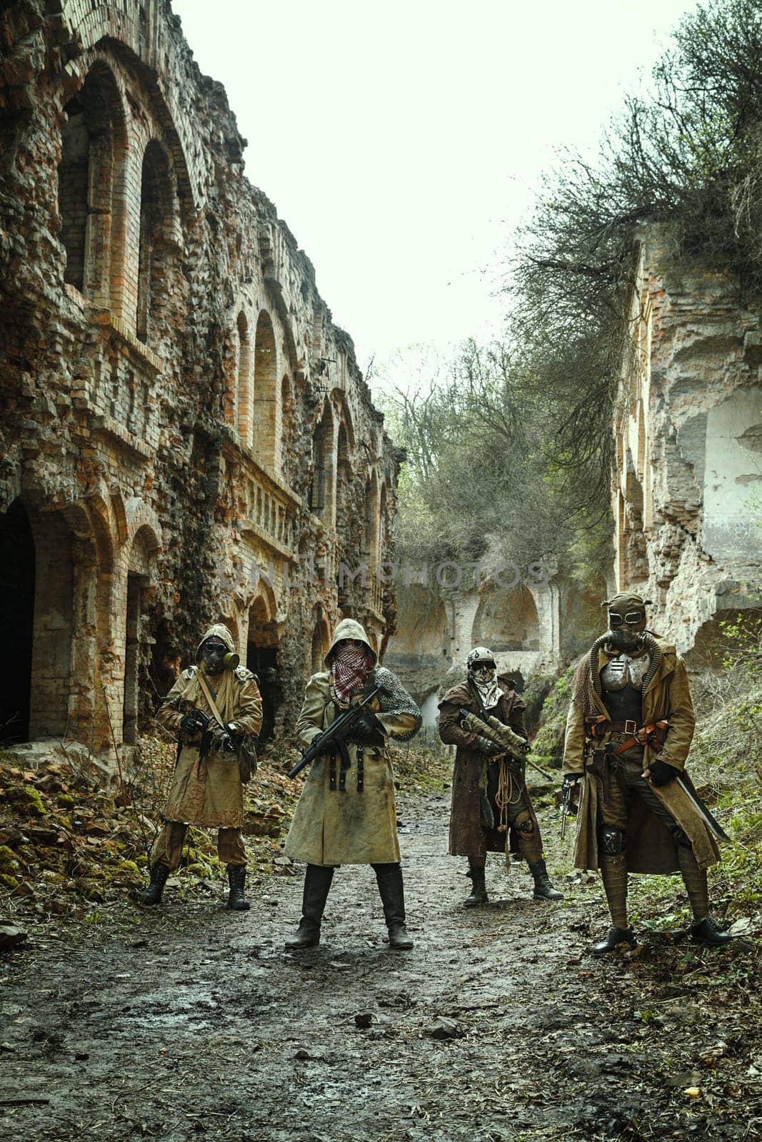 Nuclear post-apocalypse. Survivors in tatters and gas mask on the ruins of the destroyed city