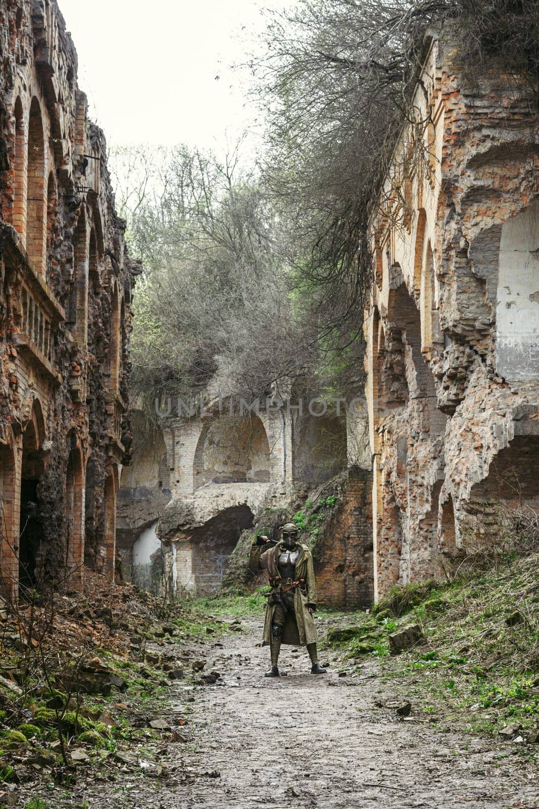 Nuclear post-apocalypse. Sole survivor in tatters and gas mask on the ruins of the destroyed city