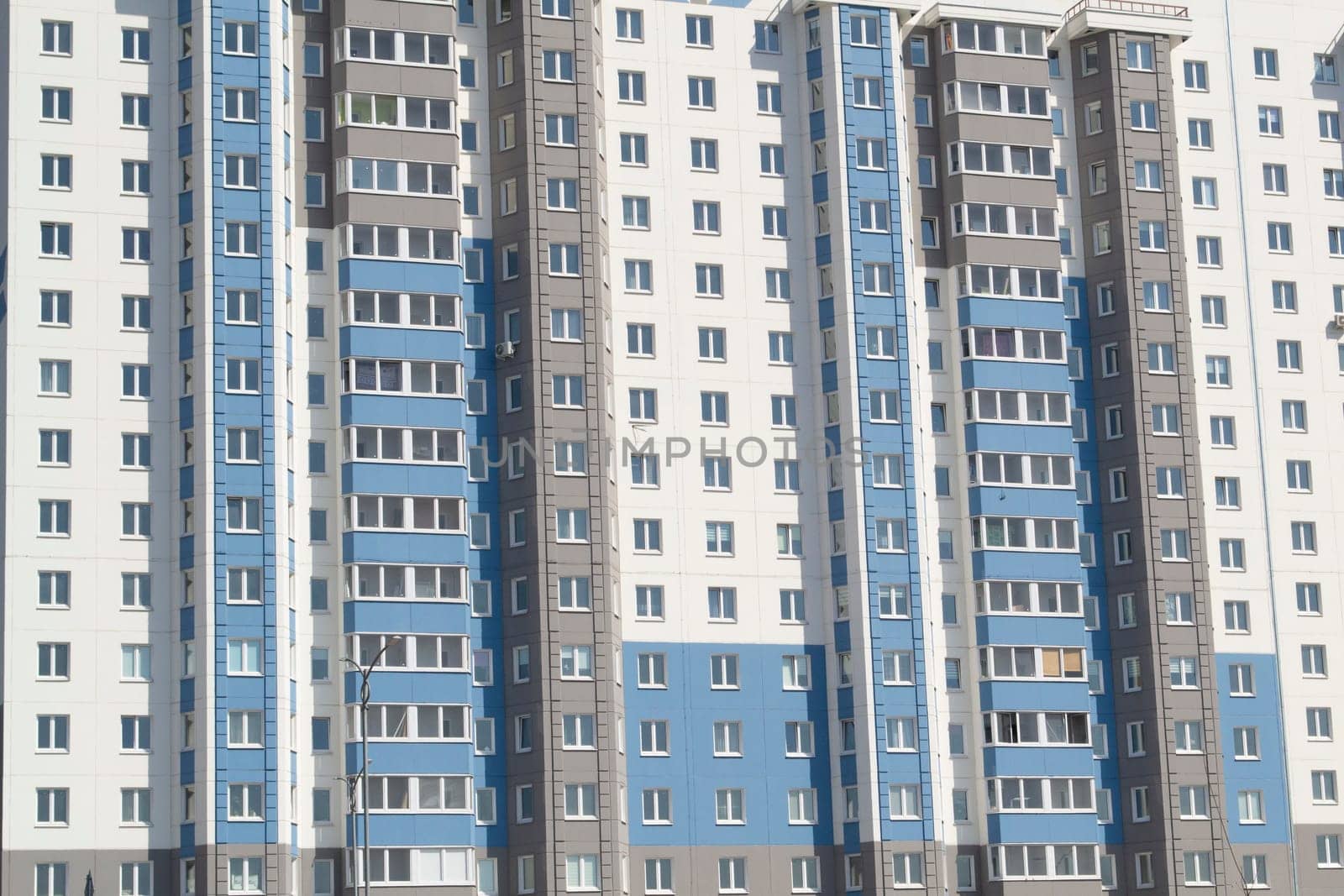 Multiple windows on a large building in the city in blue and white