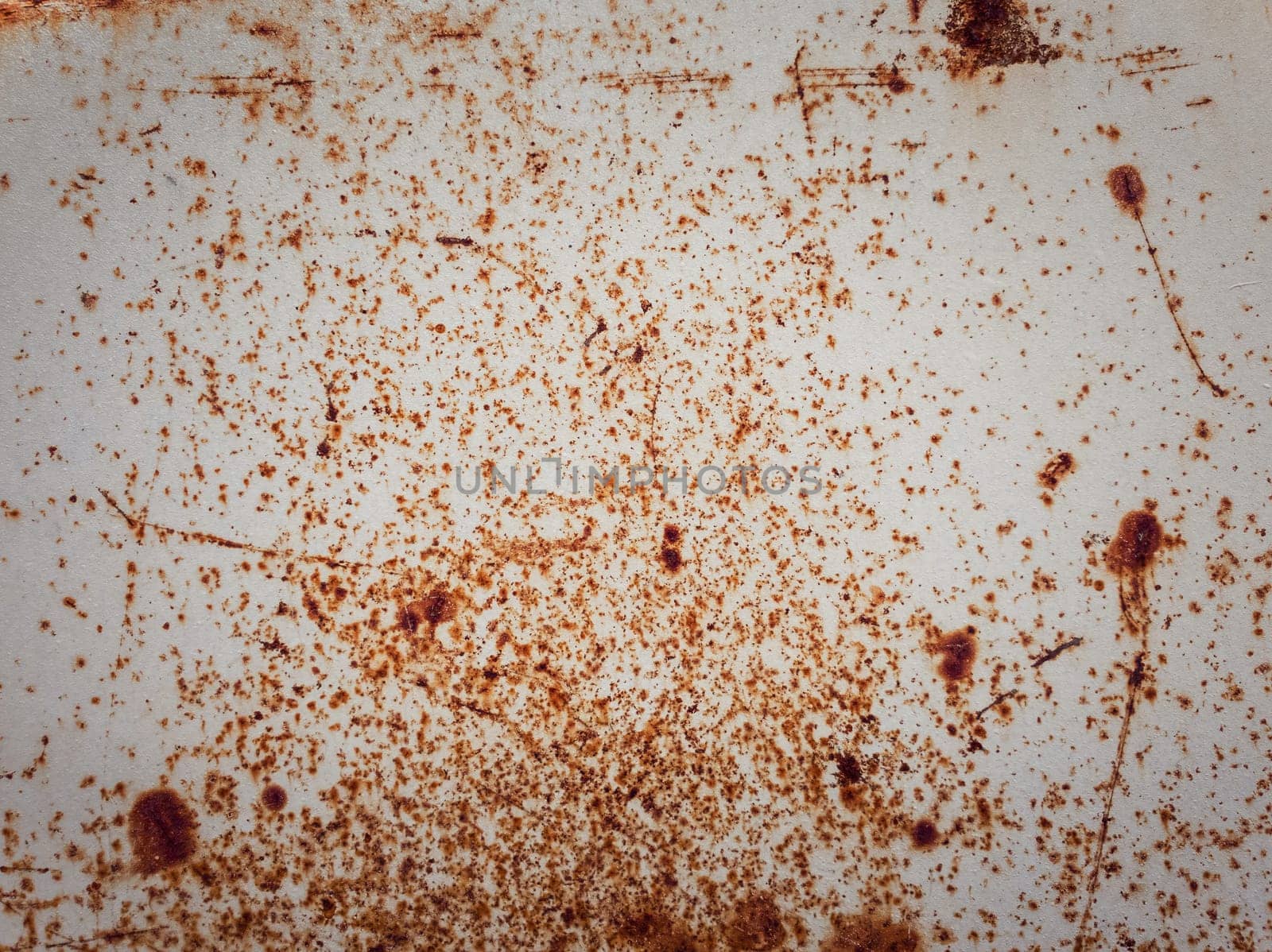 Rusty and rotten metallic structure surface. Grungy, weathered tin sheet decay. Abstract details of weathered construction element. Corrosion texture background with orange rust dots over white paint