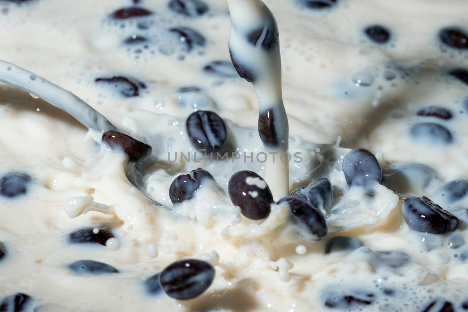Coffee beans falling on the milk splash. Cup of milk. Concept photography.