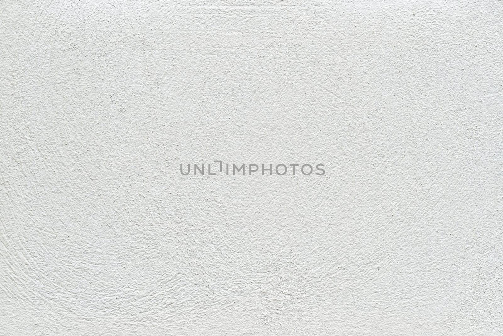 The subtle white textured surface of an external plastered wall.