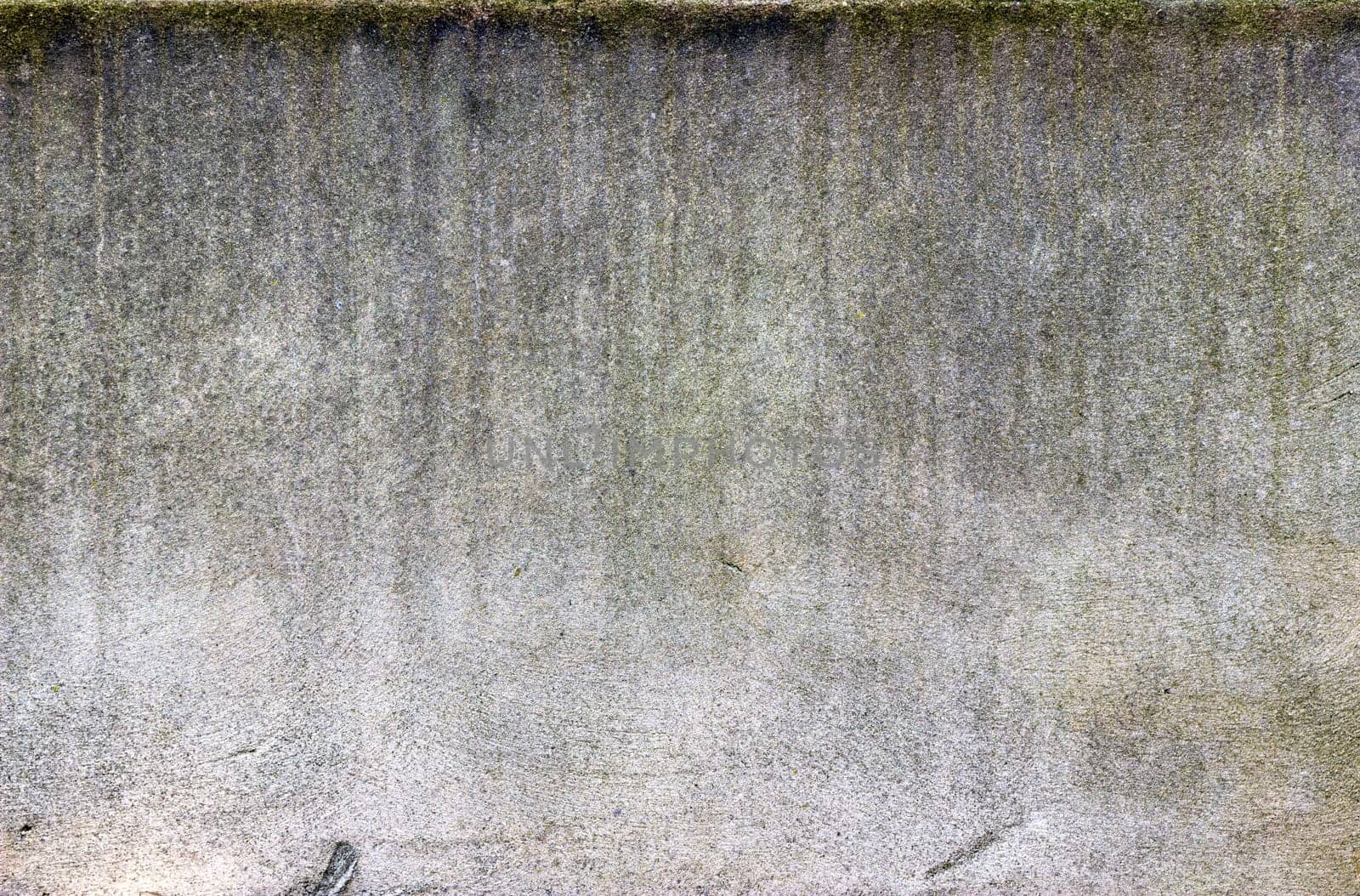 Vertical lines of dirt streak down a white heavily textured wall