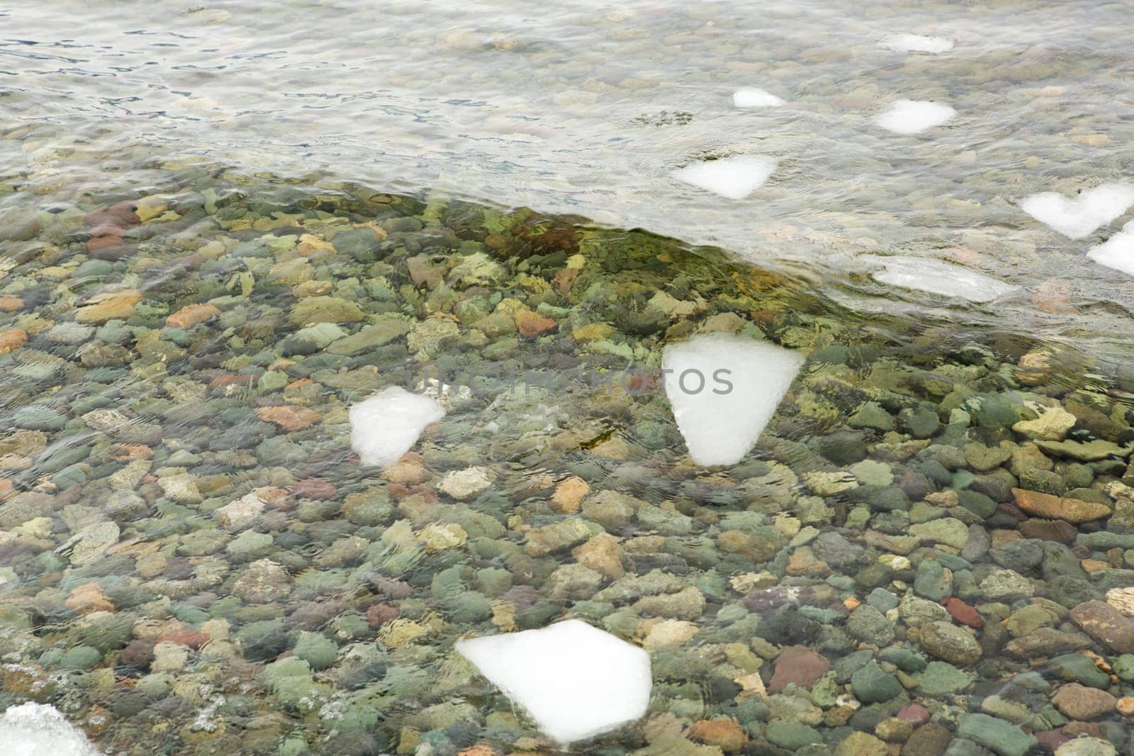 crystal clear water on Lake Teletskoye, through which you can see the stones lying on the bottom.Russia, Altai Krai.