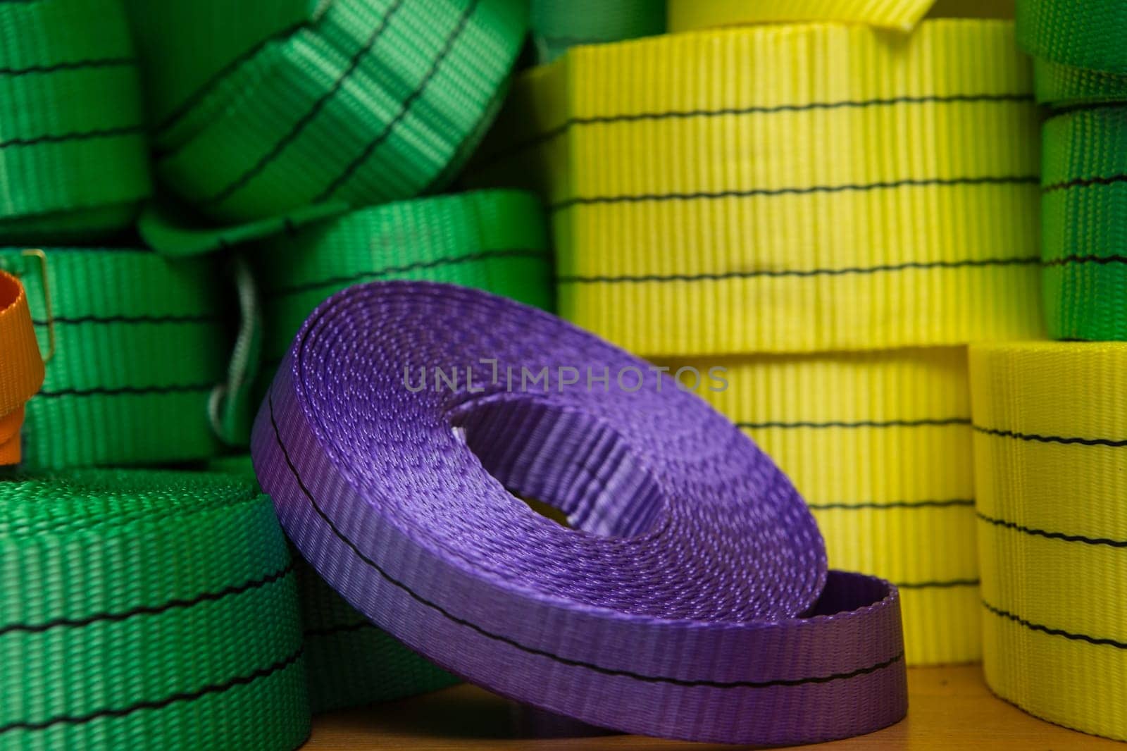 Industrial sewing machine sews a webbing sling. Manufacture of textile slings and tie straps