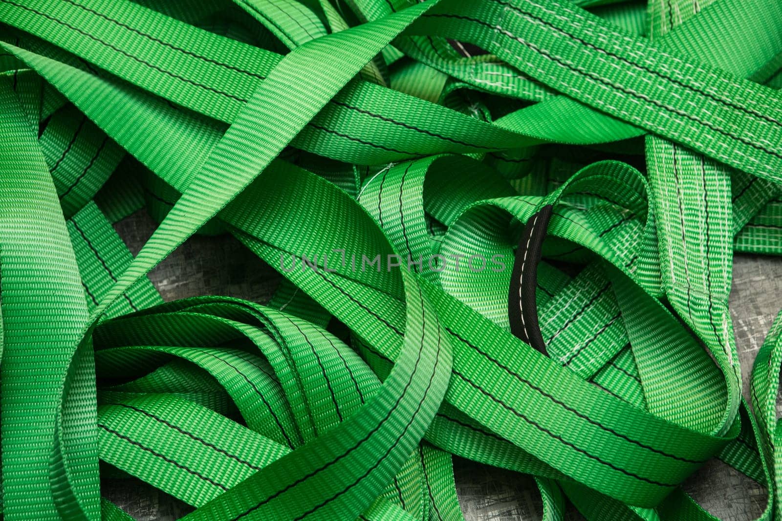 Industrial sewing machine sews a webbing sling. Manufacture of textile slings and tie straps