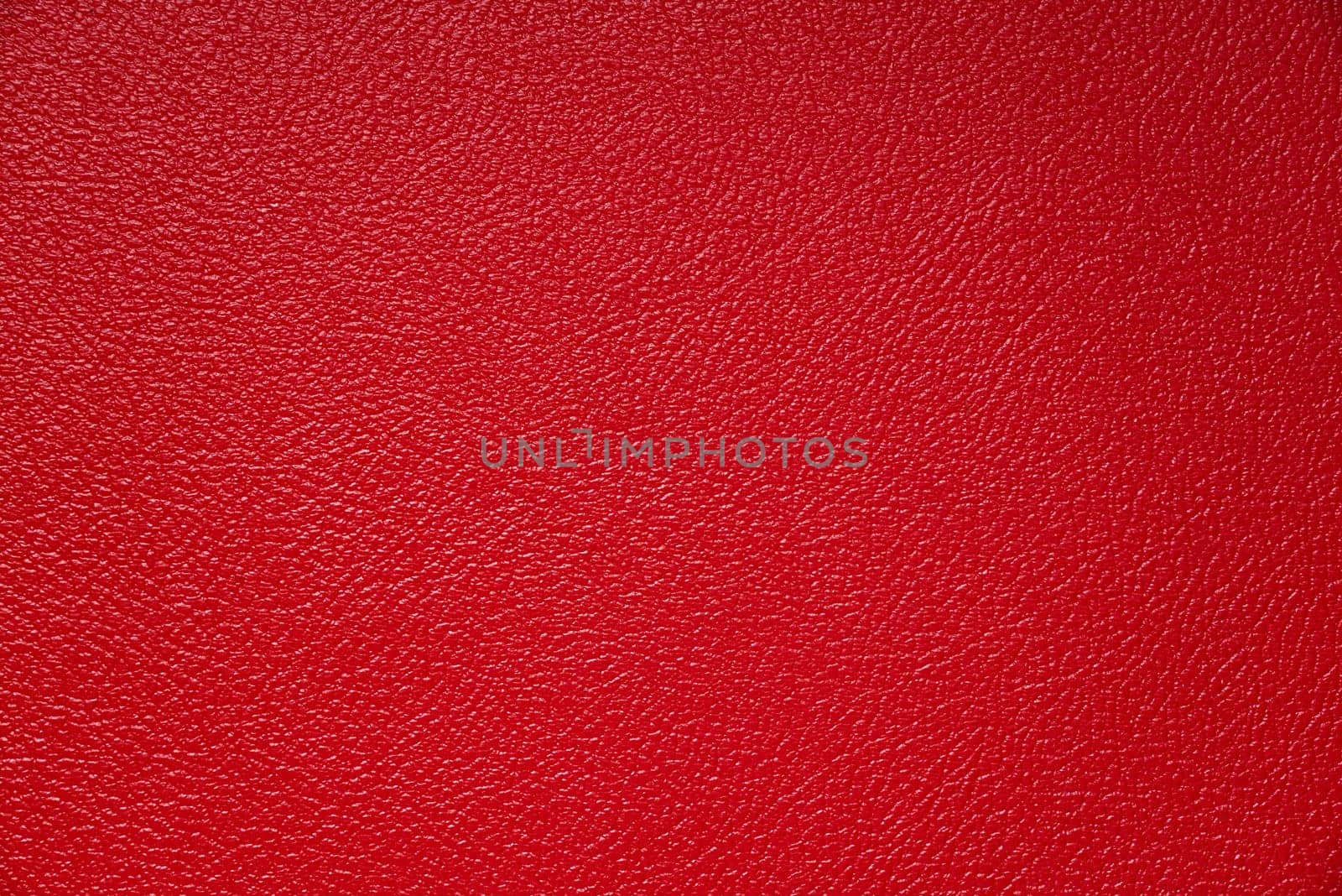 The subtle texture of red vinyl tolex on a guitar amp speaker cabinet.