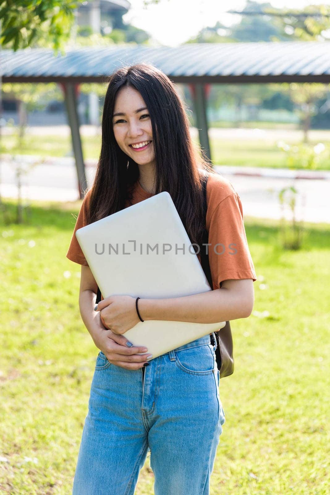 Young woman with backpack hold notebook standing in university