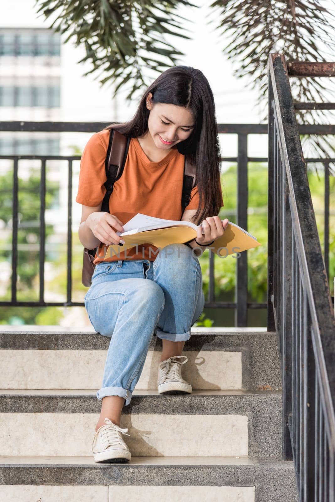 Portrait of Happy young Asian teen woman student sitting during she reading a book at university, Education back to university concept